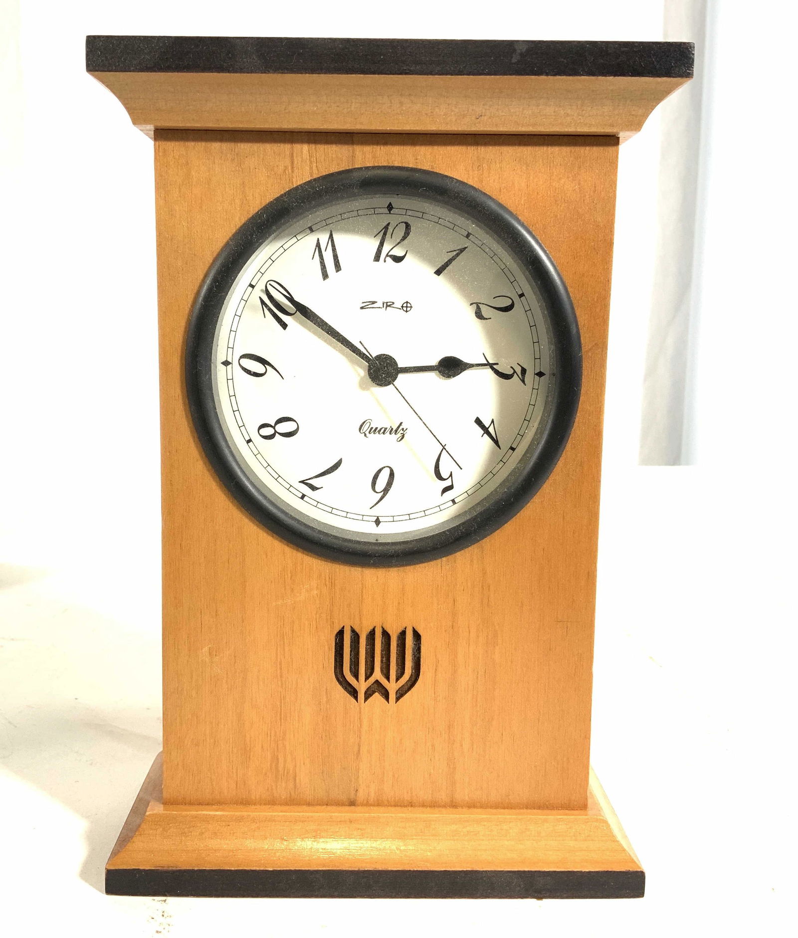 ZIRO Quartz Mantel Clock: Clock face is marked ZIRO. Piece has wood tone with white clock face & black numbers. Piece measures approx 7.25 inches tall 5 inches wide. This item was generously donated by Regis Philbin’s family