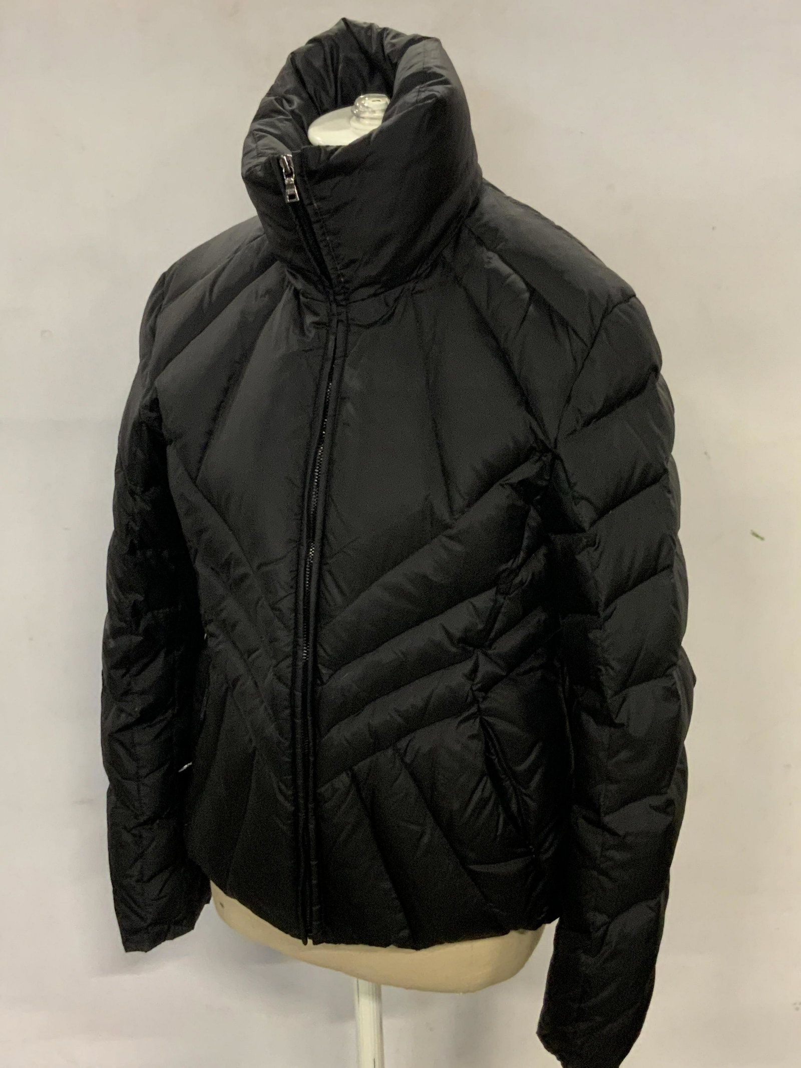 JOY PHILBIN Andrew Marc Goose Down Puffer Jacket: A black goose down puffer style jacket once owned by Joy Philbin. Two exterior pockets. Piece secures with black zipper closure. Inter tags read ANDREW MARC, M. Size Medium. Approx. Length 21 in. Jack