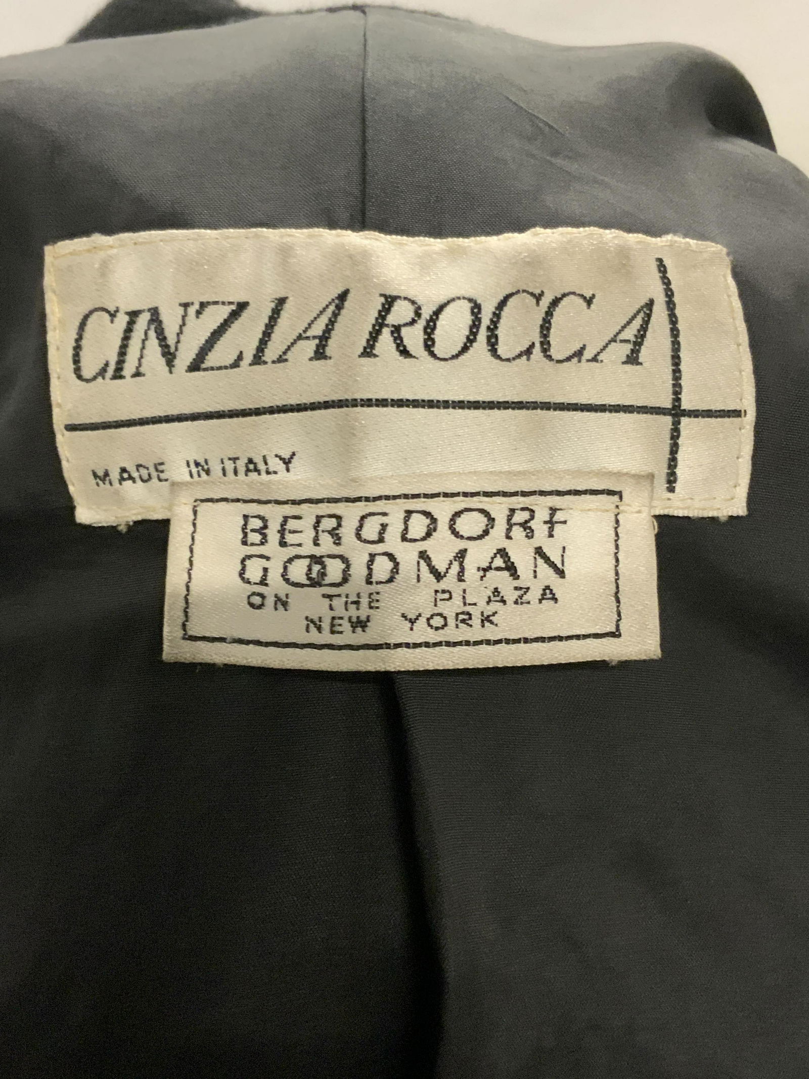 JOY PHILBIN Cinzia Rocca Italian Coat: A black coat once owned by Joy Philbin. The piece appears to be crafted from wool or a wool blend, material tag is partially illegible. Two exterior pockets. Piece secures with black button closure. I