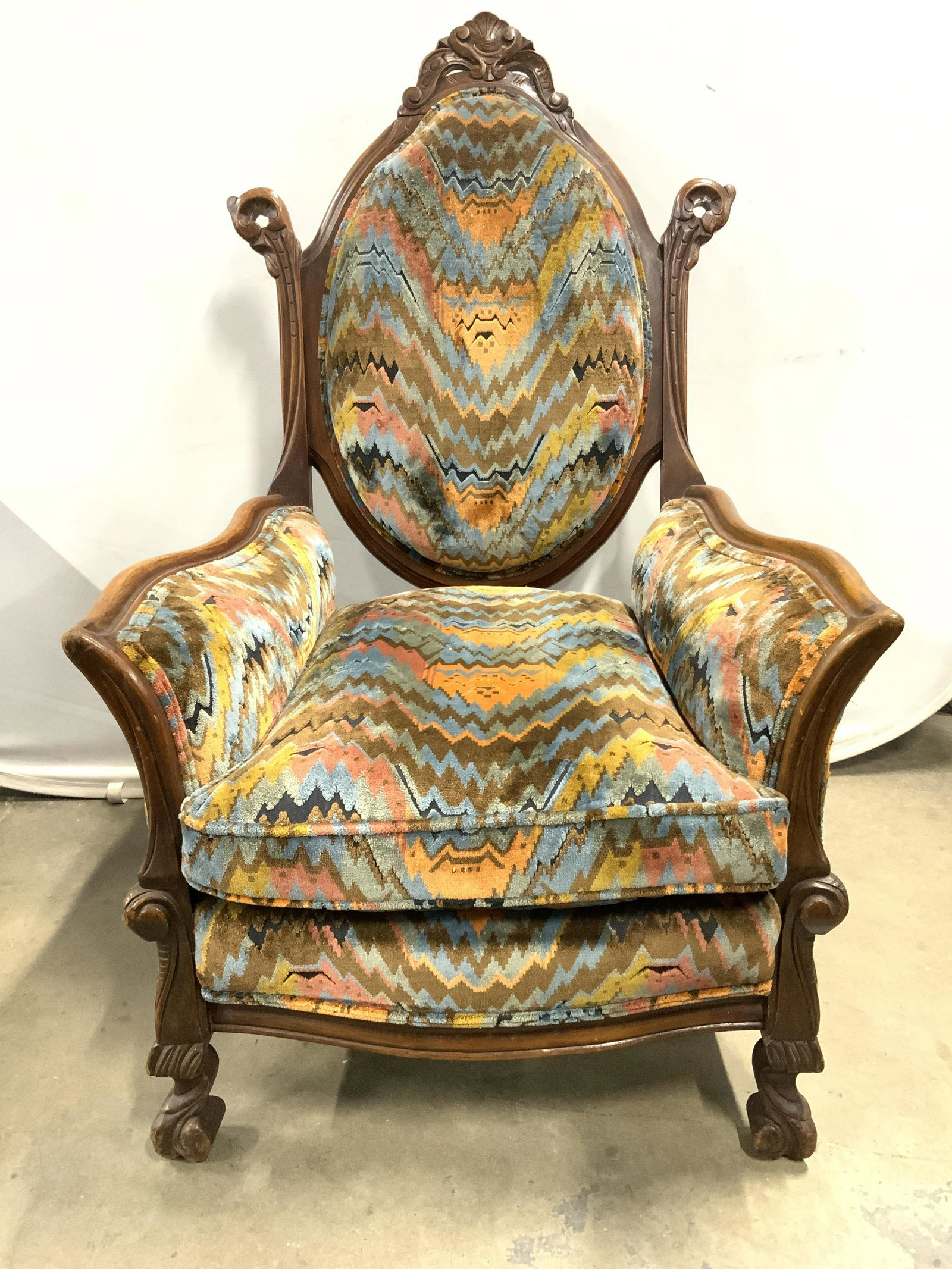 Antique Rococo Style Upholstered Armchair: Armchair is antique. Piece has rococo style. Edges of upholstery have double welting. Piece has intricately carved wooden areas. Armchair has intricately detailed geometric detail. Piece measures appr