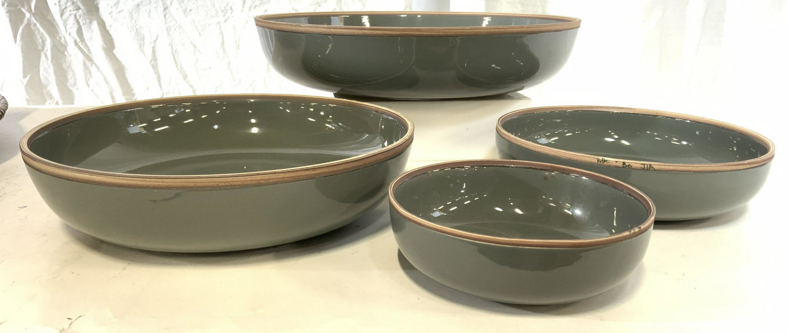 Set 4 MK BO JIA Ceramic Bowl Vessels: Rim of bowls are marked MK BO JIA. Lot includes 4 bowls. Each appear to be ceramic, possibly porcelain. Each are slate toned with brown and cream toned rim. Largest piece measures approx 14 inches wid