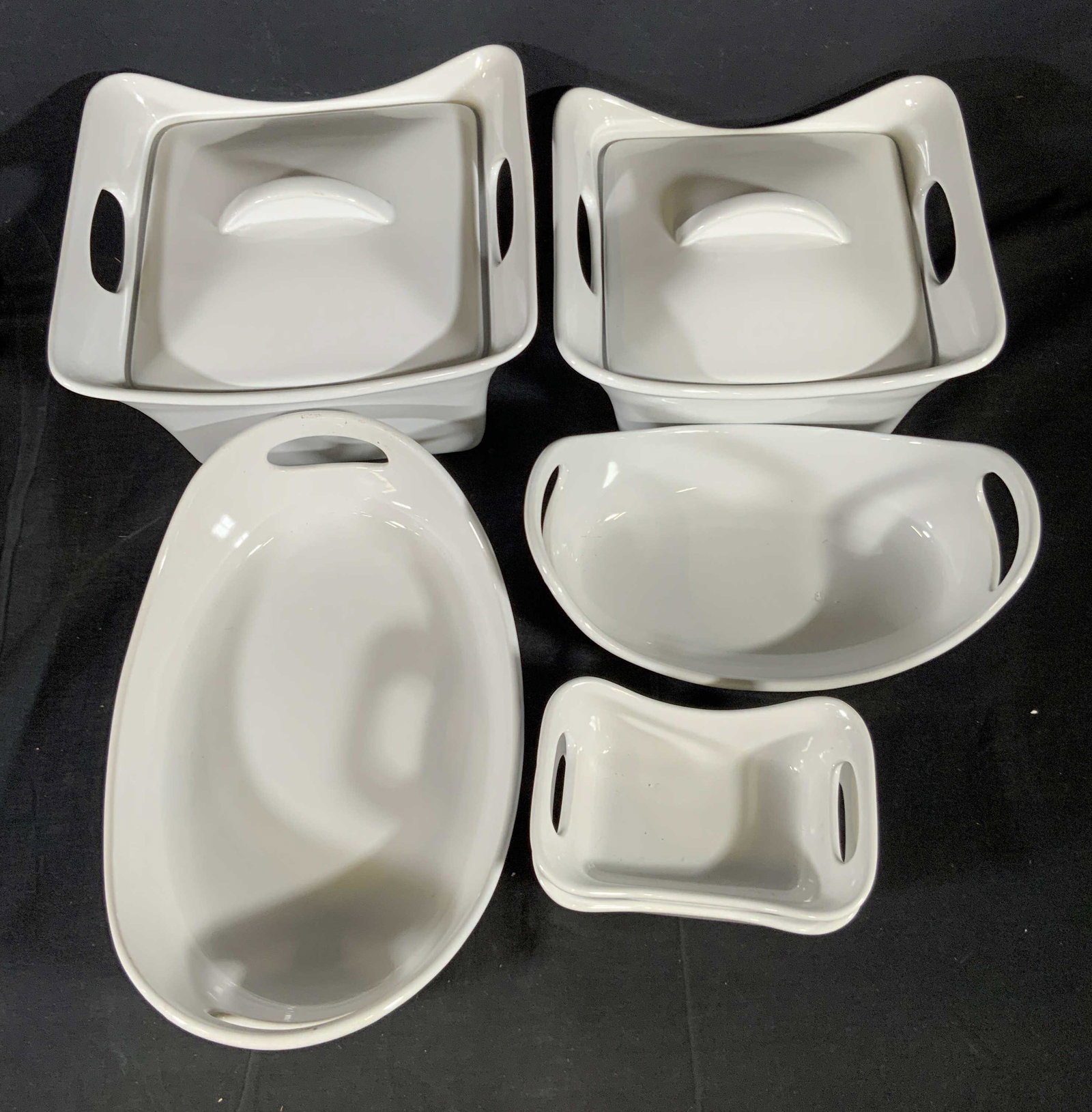 Set 6 RACHEL RAY White Porcelain Service Ware: Six pieces of white porcelain serviceware from Rachel Ray’s collection. The undersides are all signed RACHEL RAY. All pieces are crafted from thick walled porcelain and have handled sides. Some piec