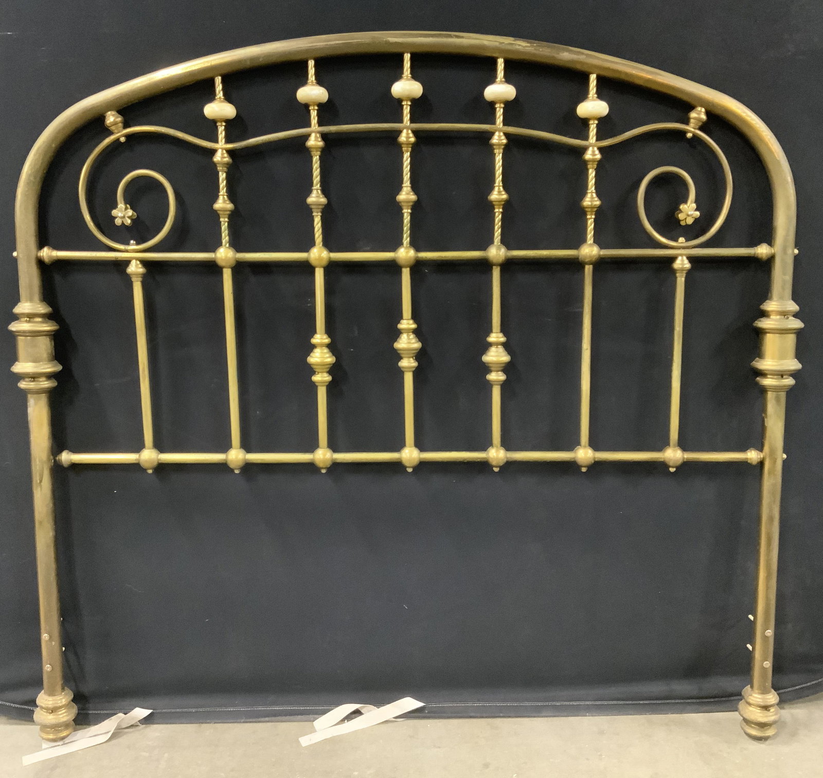 Vintage Ornate Brass Head Board: Head board is vintage possibly antique. Piece is gold toned and brass. Piece has arched top. Sides near top have floral detailed structures. Piece measures approx 52 inches long 58 inches tall. Head b