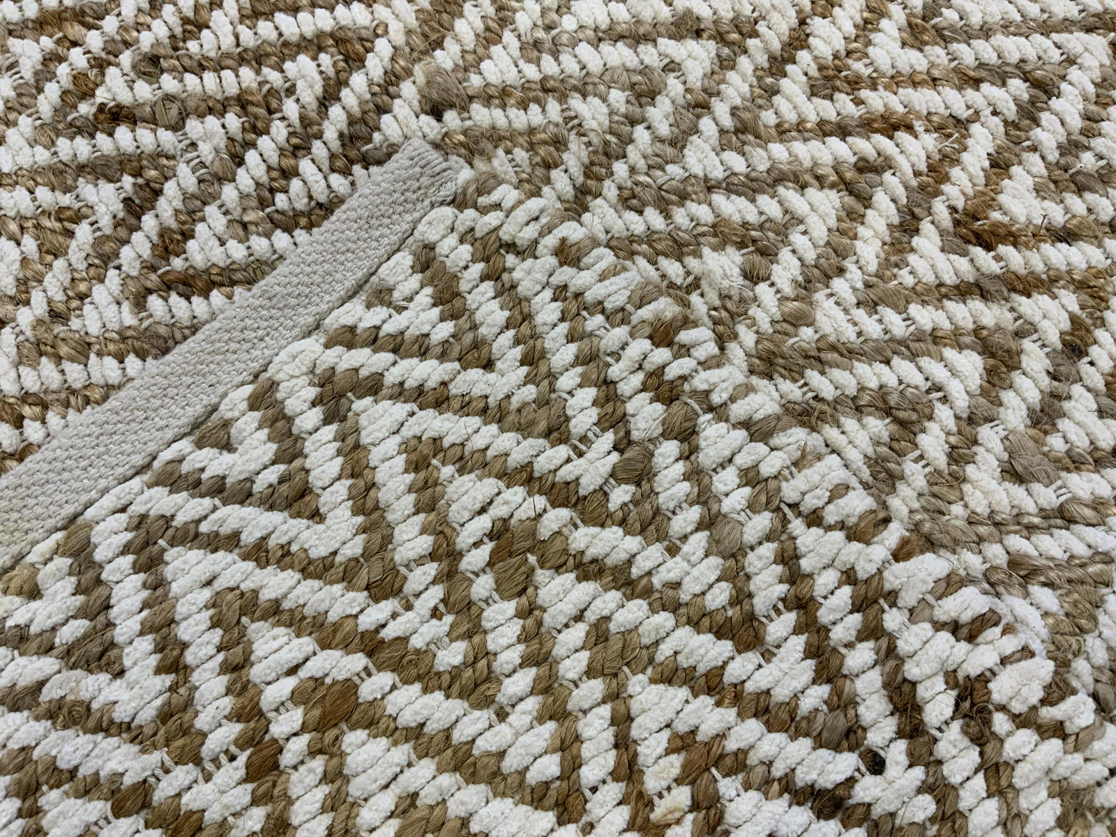 WEST ELM Jute Herringbone Rug, India: West Elm Herringbone Rug is decorated with a zigzag pattern. Crafted from jute and cotton. Label reads as WEST ELM JUTE CHENILLE HB TAPIS, lists dimensions as well as care instructions. Measures appro