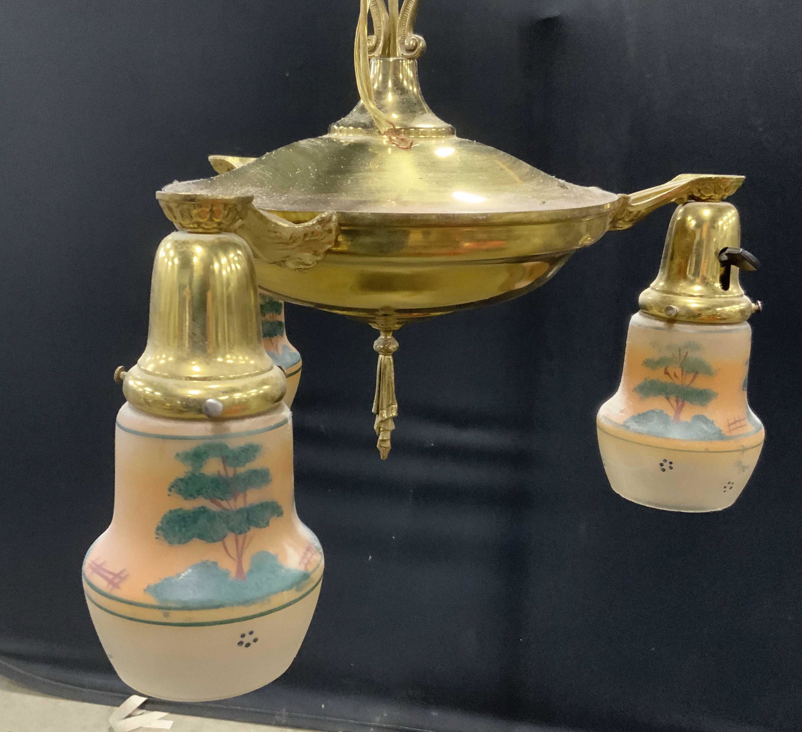 Vintage Light Fixture & Hand Painted Shades: Vintage brass light fixture. Three armed, each socket is equipped with a glass shade, each shade is hand painted, depicting several trees as well as wooden fencing. Measures approx 21 inches H, and 18