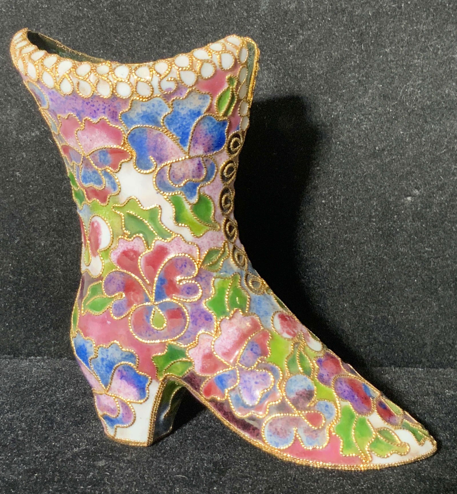 Cloisonné Heeled Shoe Form Figural: A decorative cloisonné shoe form figural. The piece features vibrant pinks, blues, greens, and more. Raised gold hued metal accents the piece. Interior is glazed green. Approx. 3.5H x 3.5W in. Cloiso
