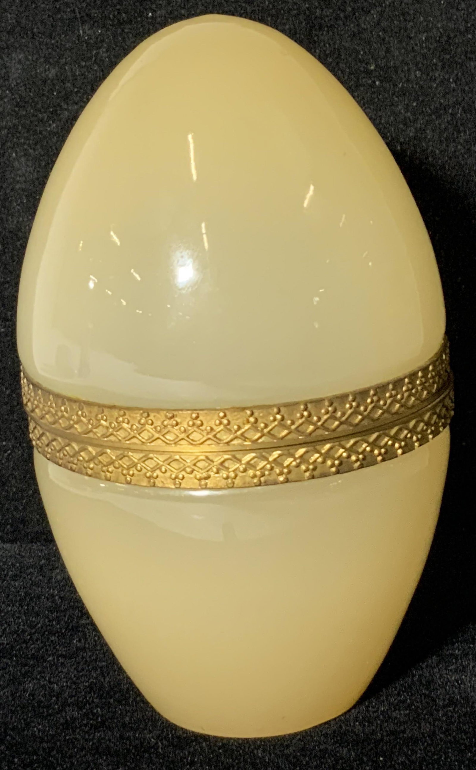 Art Glass Egg Form Trinket Box: A yellow hued lidded glass trinket box. Slight ombré hue. Piece is egg formed. Operates with gold toned hinged hardware. Approx 5H x 3W in. Egg form, egg figural, decorative arts, decorative object, 
