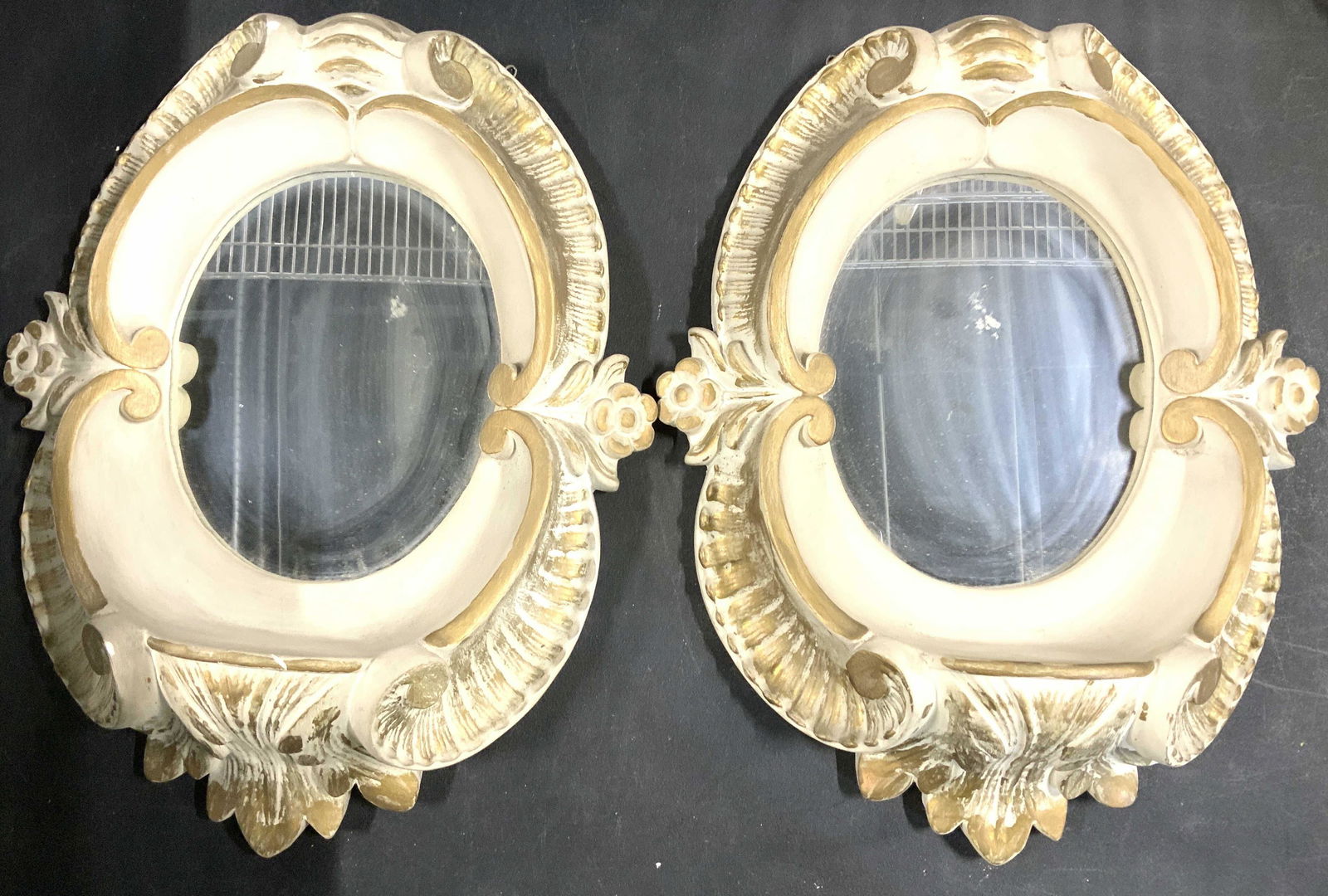 Pair Gold Leaf & Terra Cotta Sculpted Wall Mirrors: Painted Terra Cotta Cast Mirrors with small shelf for a candle or other object to reflect in mirror. Mirror specially cut to fit into backside opening. Frontside oval cut. Gold leaf wash over natural