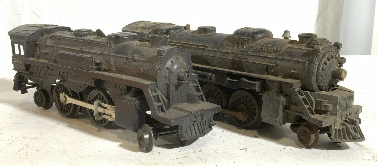 Lot 2 Vintage LIONEL Metal Toy Trains: Undersides of each read LIONEL. Lot includes 2 toy train engines. One is metal the other appears to be plastic. Pieces are vintage possibly antique. Each measures approx 10 inches long 3 inches tall 2