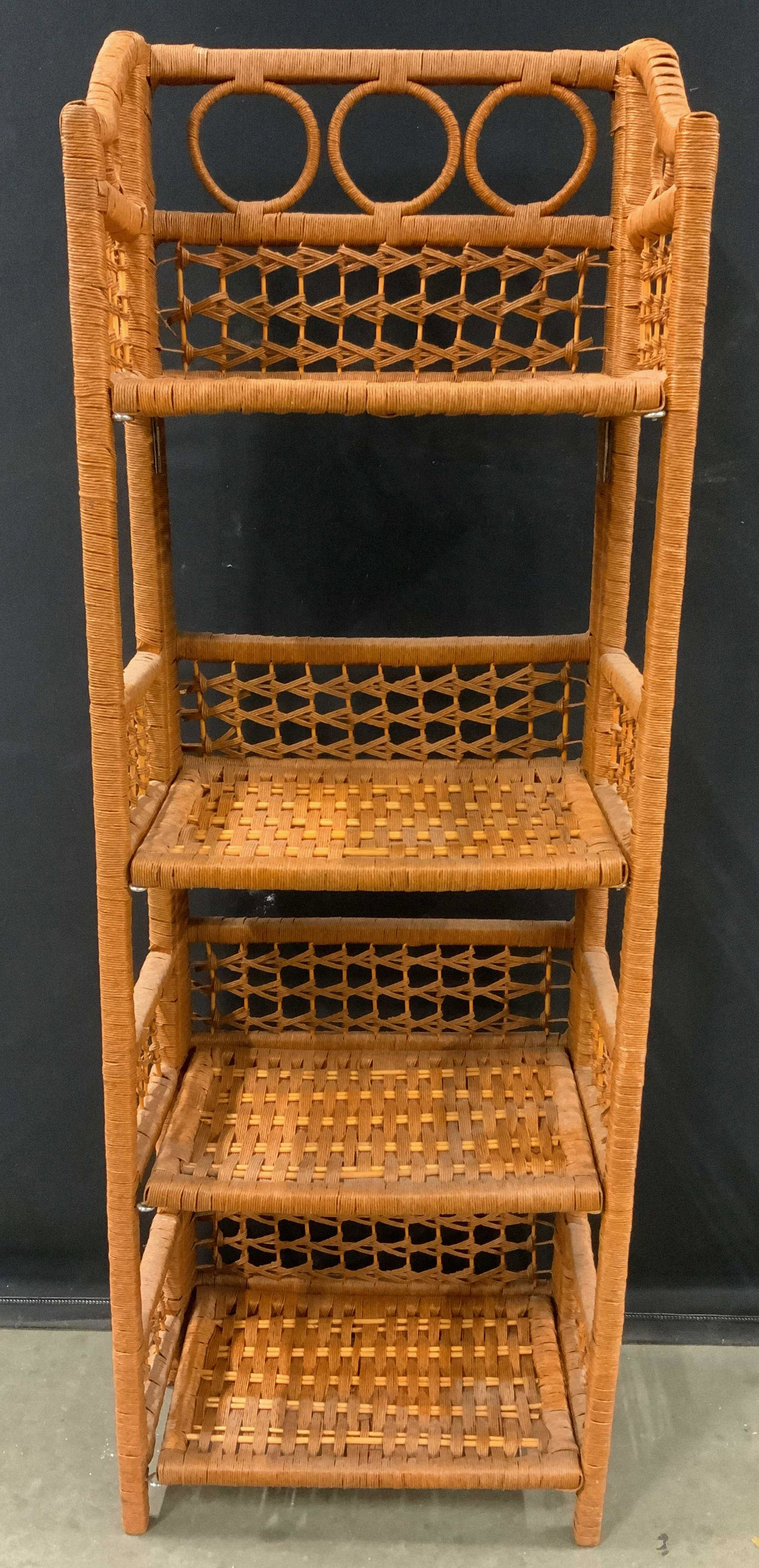 Woven 4 Tier Folding Shelves: Shelves are orange toned. Piece has woven structures appears to possibly be wicker. Each shelf folds upward towards backside of piece. Top of shelf has 3 woven circular structures. Piece measures appr