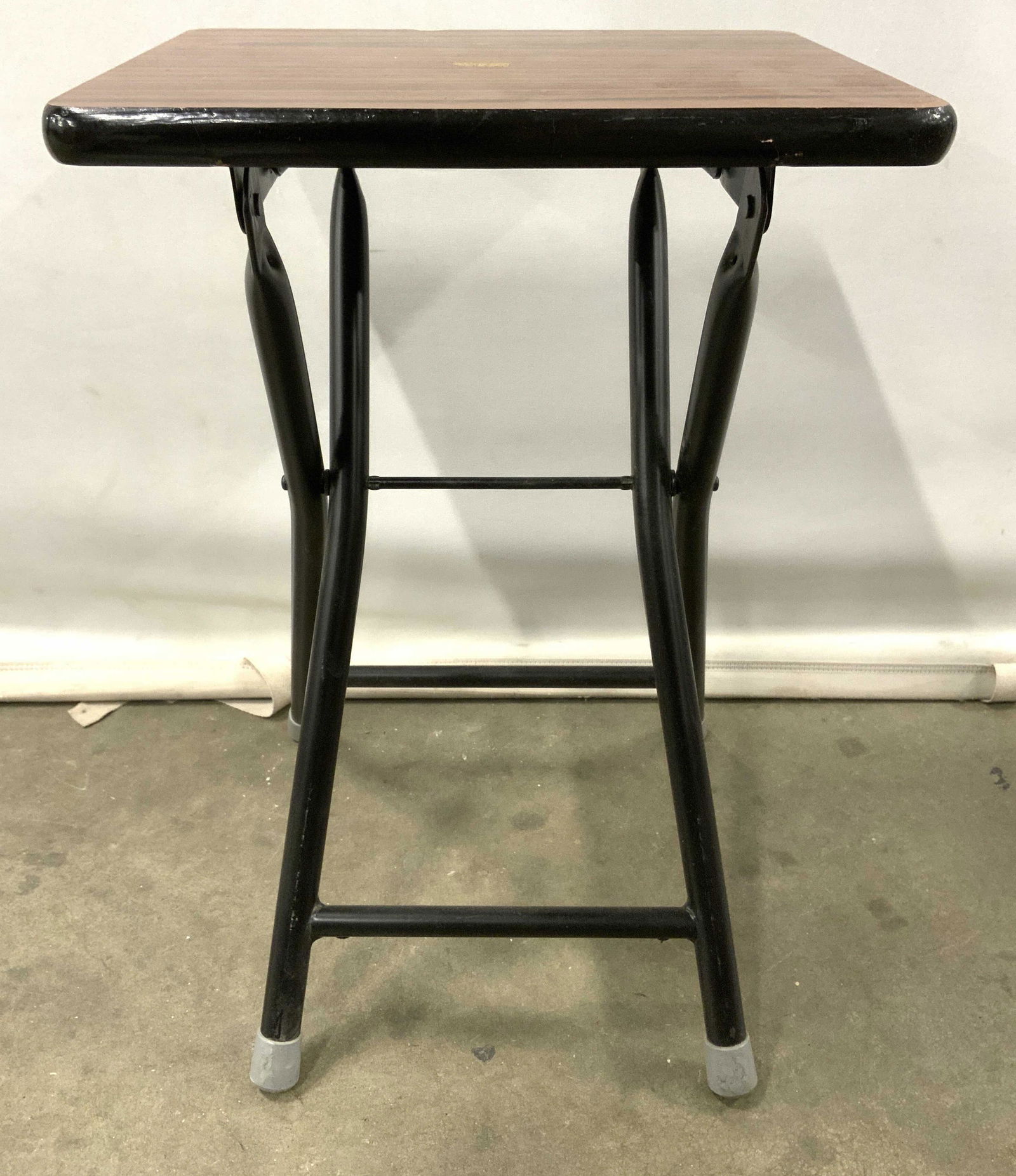 Vintage Metal Folding Table, Stool: Piece is vintage and has metal frame which folds. Top of piece appears to possibly be wooden, possibly veneer. Feet have slate toned caps. Top of piece has various tones of brown with wooden textured