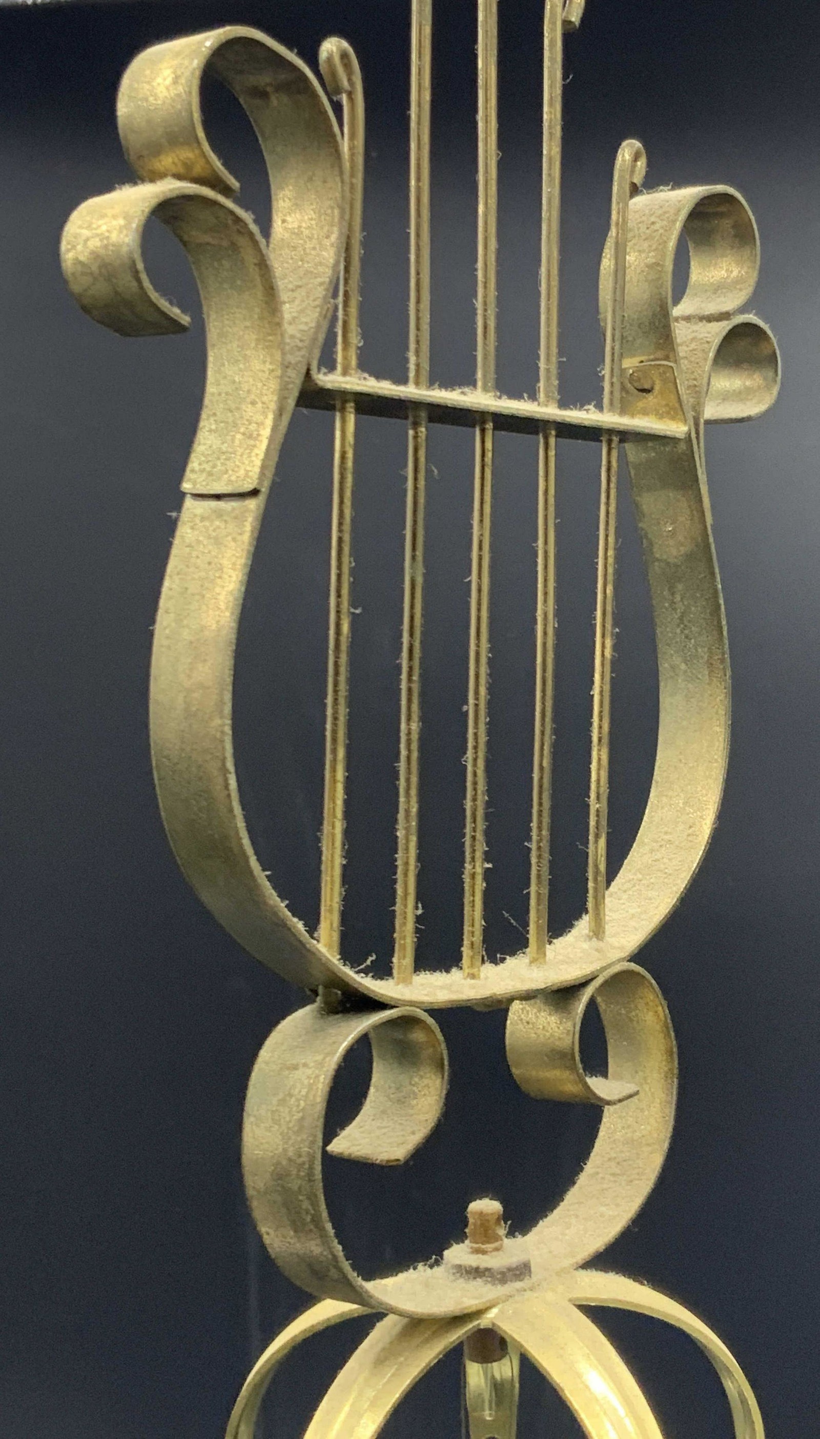 Vintage Brass Wind Chime: A metal, possibly brass, vintage wind chime. The piece has a harp form at the top, open metalwork hearts in the center, and what appears to be an Asian character at the base. Approx. 23H x 3W in. Prop