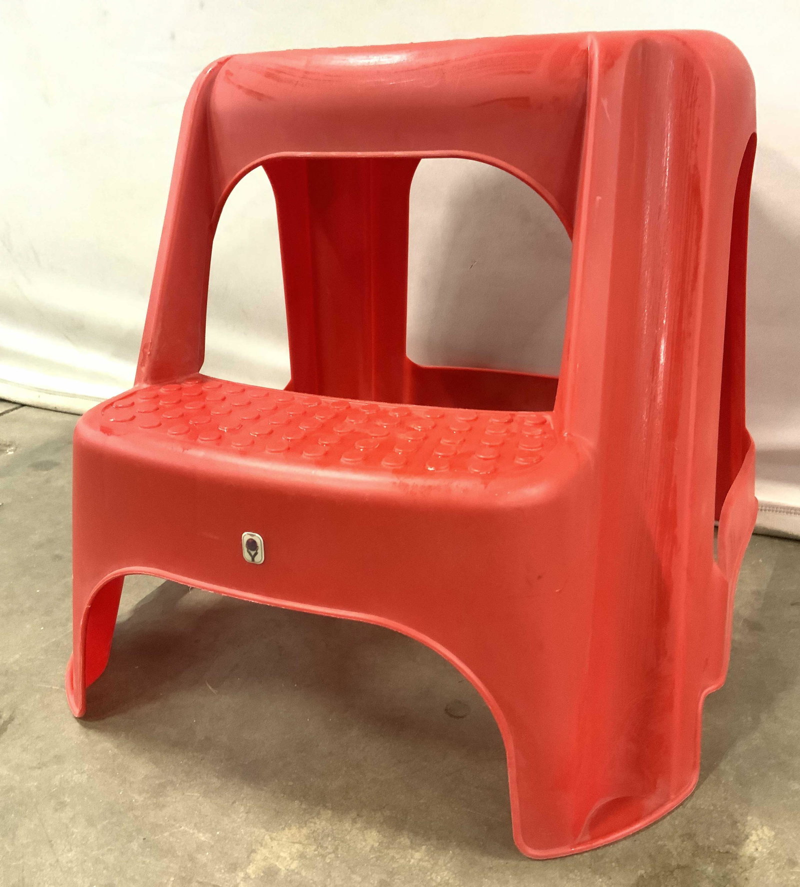 Vintage Retro Red Plastic Kitchen Step Stool: Step stool is red toned & appears to be plastic. Piece has beveled dot detail on top. Center of top has oval shaped negative space. Piece measures approx 17 inches tall 16 inches wide 20 inches deep. 