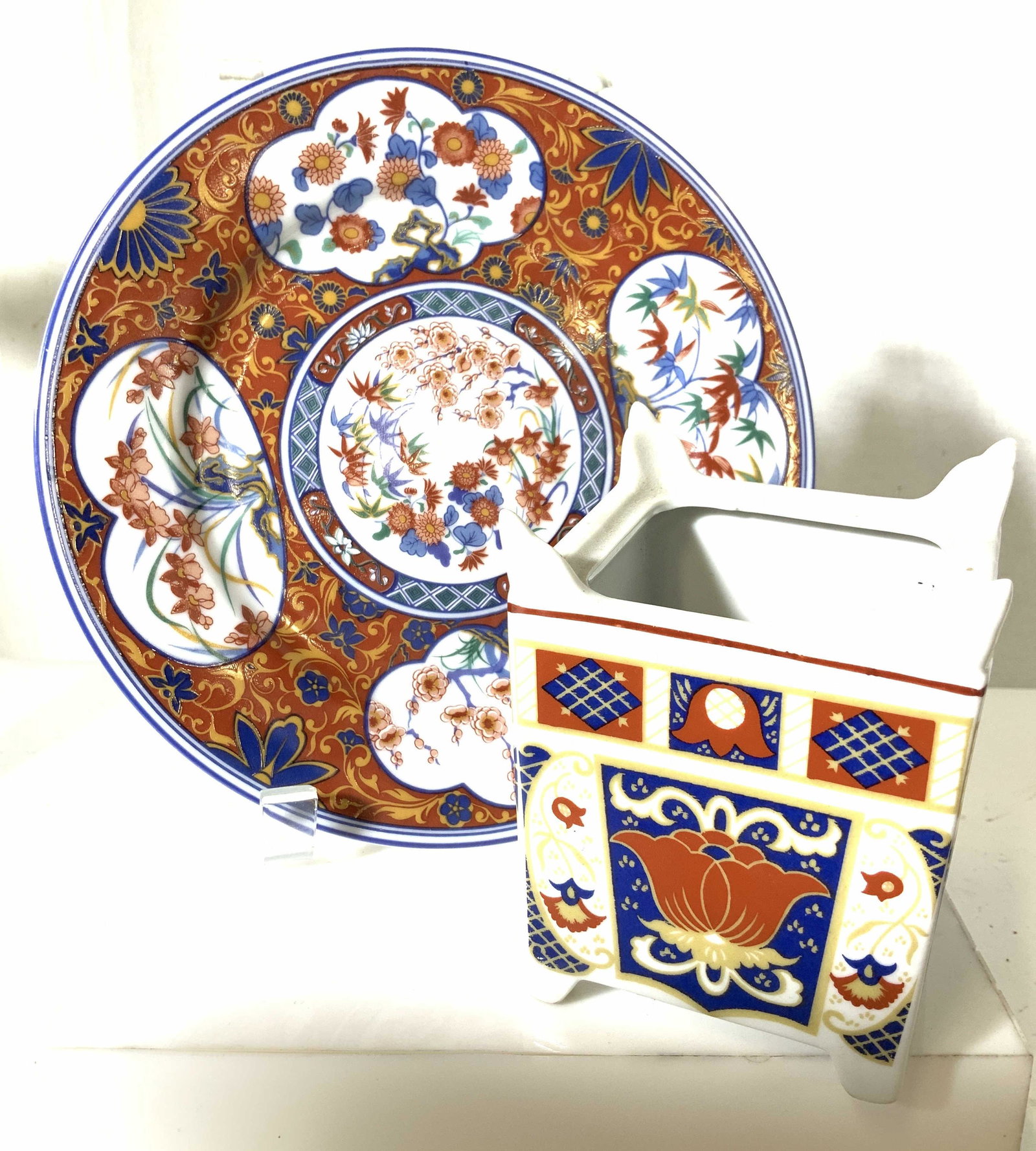 Group 2 FINE Asian Porcelain Plate & Shelf Planter: LAKLAIN FINE CHINA BY DANKOTUWA PORCELAIN. Hallmarked as such, 8 in. Heavily painted with Japanese florals, 4 cartouches in a palette of rust, blue, white and orange. Porcelain planter/Asian cache pot
