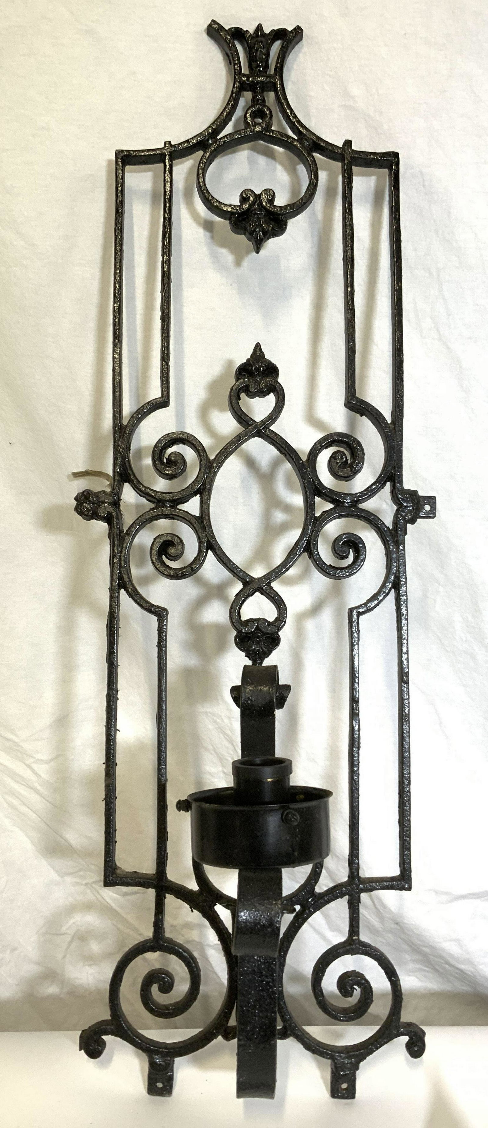 Vintage Wrought Iron Wall Sconce: Vintage, possibly antique, wrought iron wall sconce. Wrought iron wall accessory has been electrified. Measures approx 32.25 inches H, 11.25 inches W, and 8 inches deep. Wear is consistent with age an