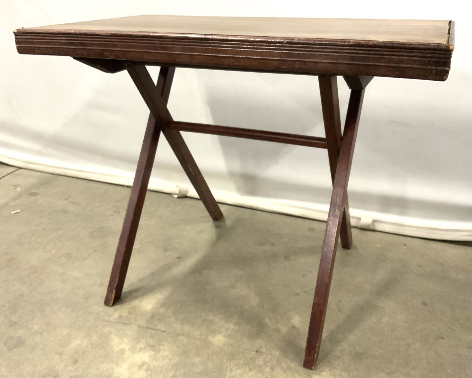 Vintage Low Wooden Folding Table: Folding table is vintage possibly antique. Table appears to be wooden possibly veneer. Piece measures approx 25 inches long 20 inches tall 14 inches deep. Table, folding table, low table, vintage tabl