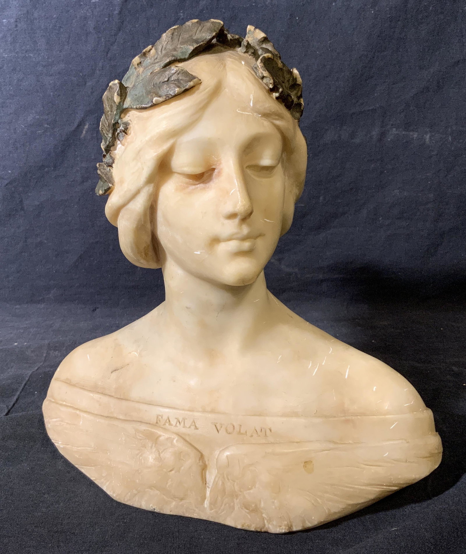 Hand Carved Stone Bust, Art Nouveau: Hand carved stone bust, possibly made of soapstone or alabaster, text to front reads ‘Fama Volta’ which translates to Fame Flies, text and possible signature to reverse illegible, subject a female