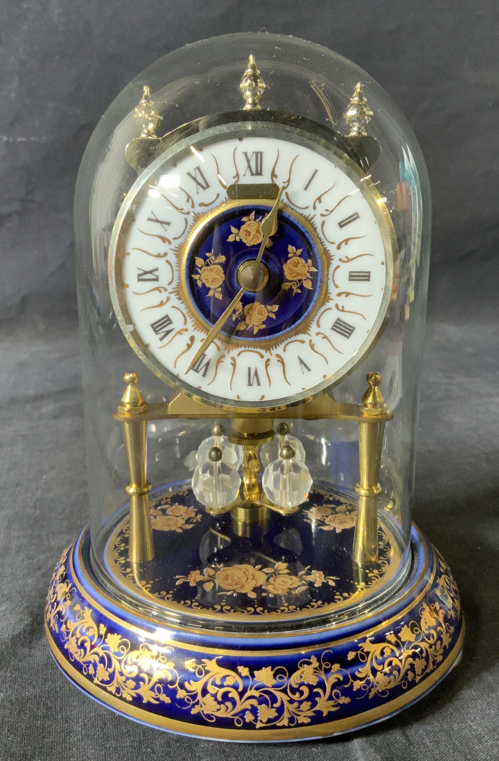 Vintage BENCHMARK Clock with Rotating Pendulum: Vintage BENCHMARK Clock with Rotating Pendulum, inscription reads ‘Benchmark W Germany’ inscription to base reads ‘D Reine Handarbeit’, measures 6 7/8 inches tall x 5 1/4 inches in diameter at