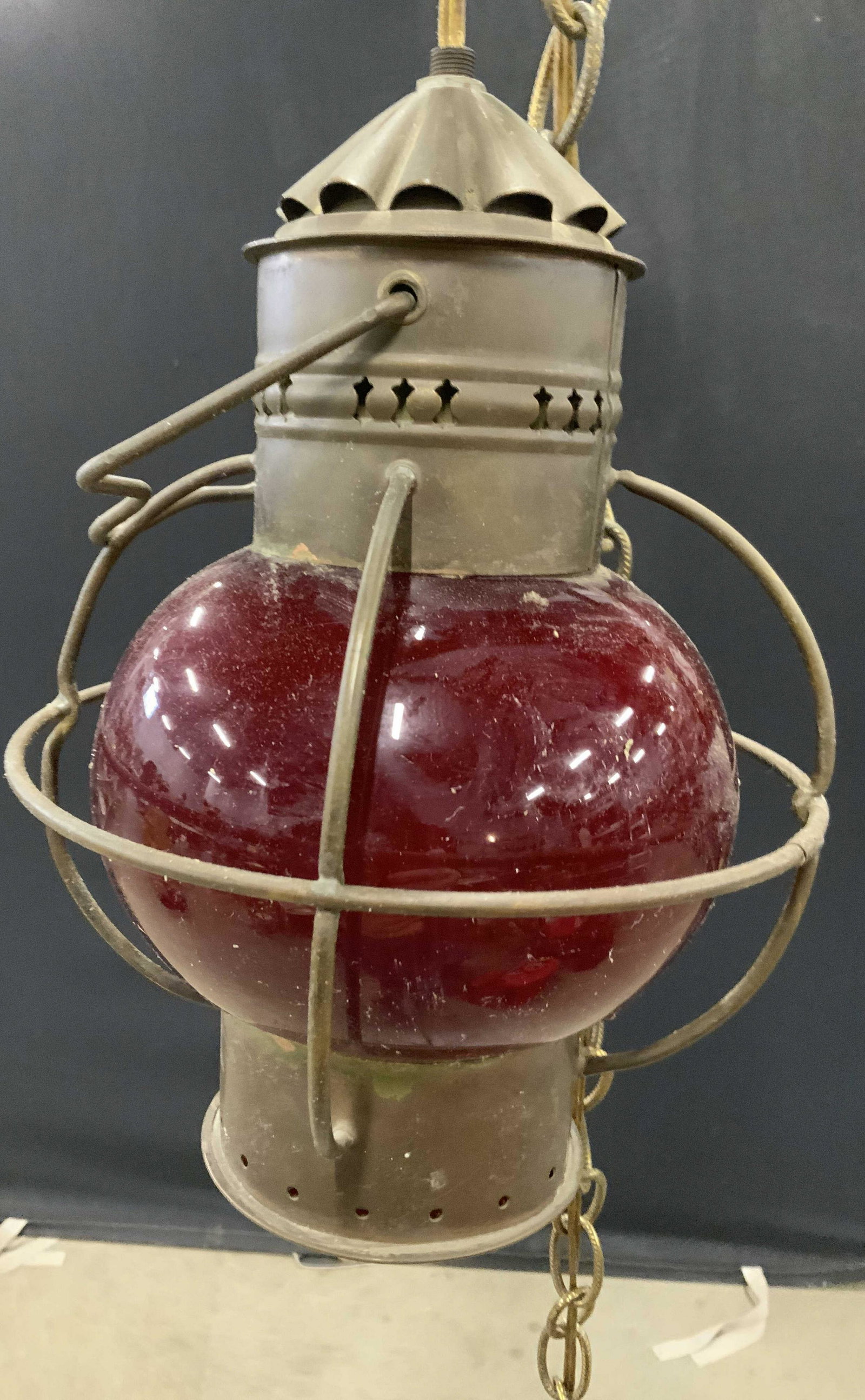 Vintage Railroad Lantern Pendant Light: Vintage lantern converted to a pendant light. Glass is red toned, frame appears to be brass. Chain and wiring affixed to lantern, converted to a pendant light. Measures approx 10.5 inches H, and 8 inc