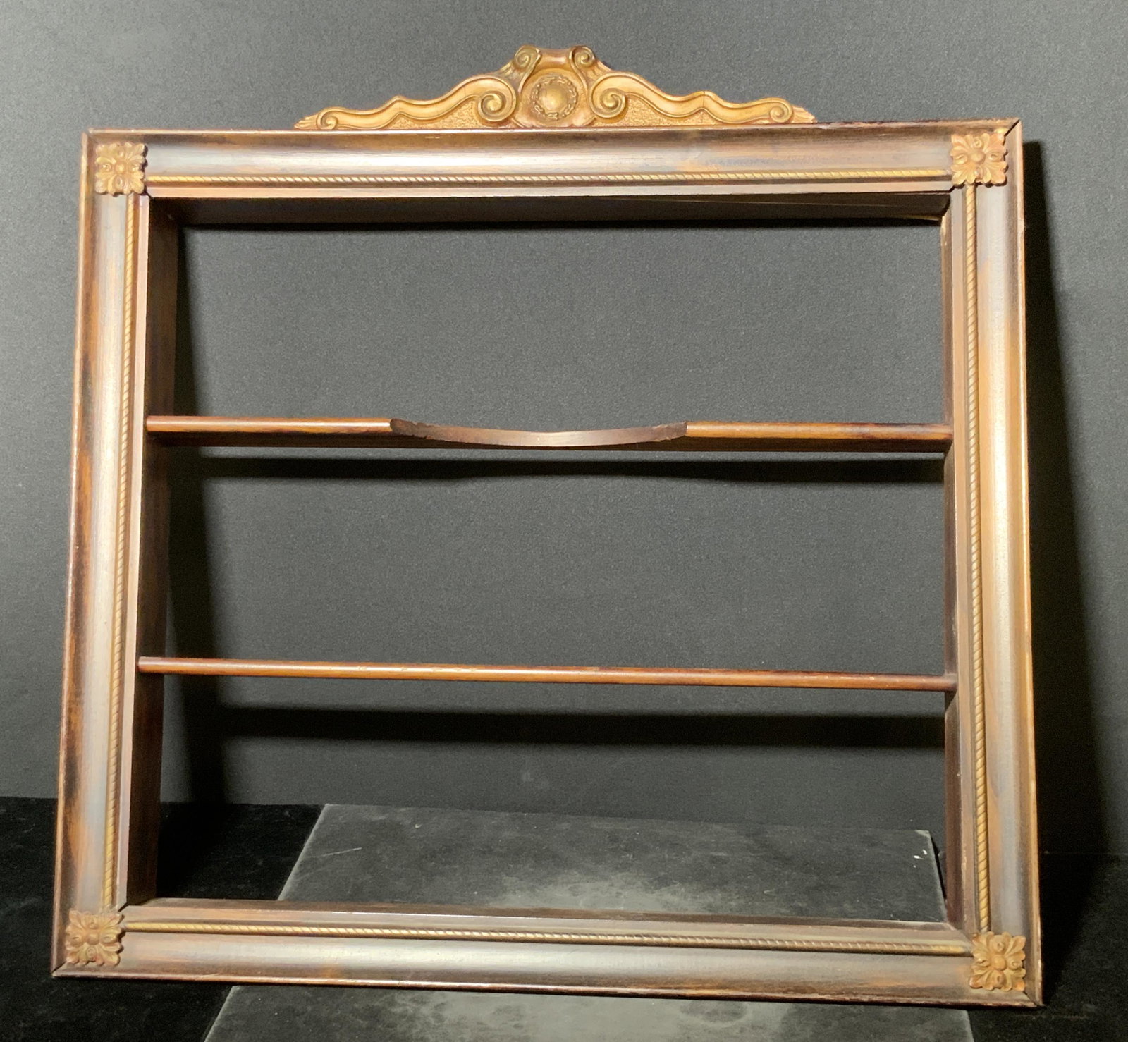 Vintage Carved Wooden Wall Shelf: A vintage rich brown carved wooden wall shelf. There are three shelves. The upper shelf has a decorative carved design which distinguishes it from the lower two. Piece can be used for displaying colle
