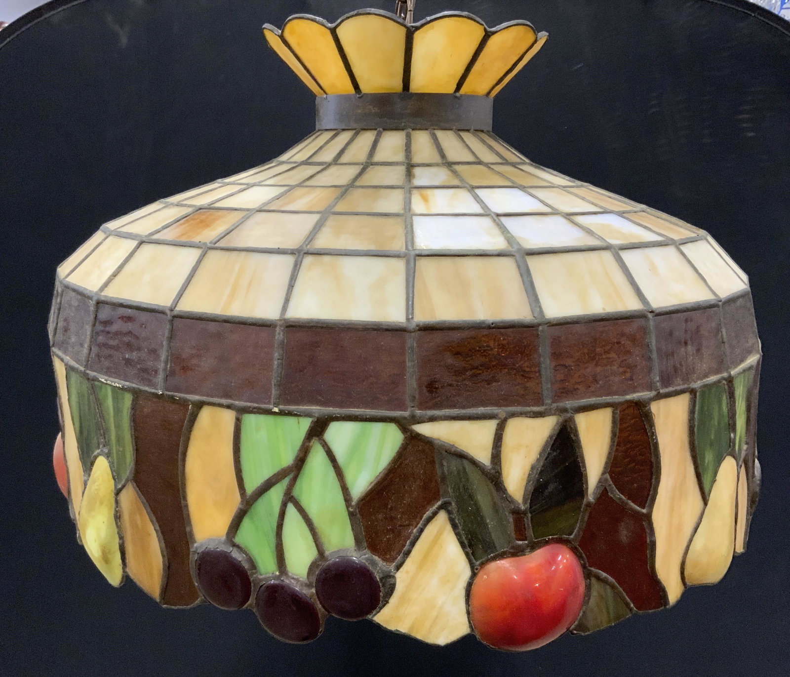 Tiffany Style Glass Shade Ceiling Fixture: Tiffany style light fixture, crafted from glass. Shade is multi toned, rim crafted to resemble various fruit. Cracking and fractures present on lamp shade. Measures approx 15 inches h, and 21.5 inches