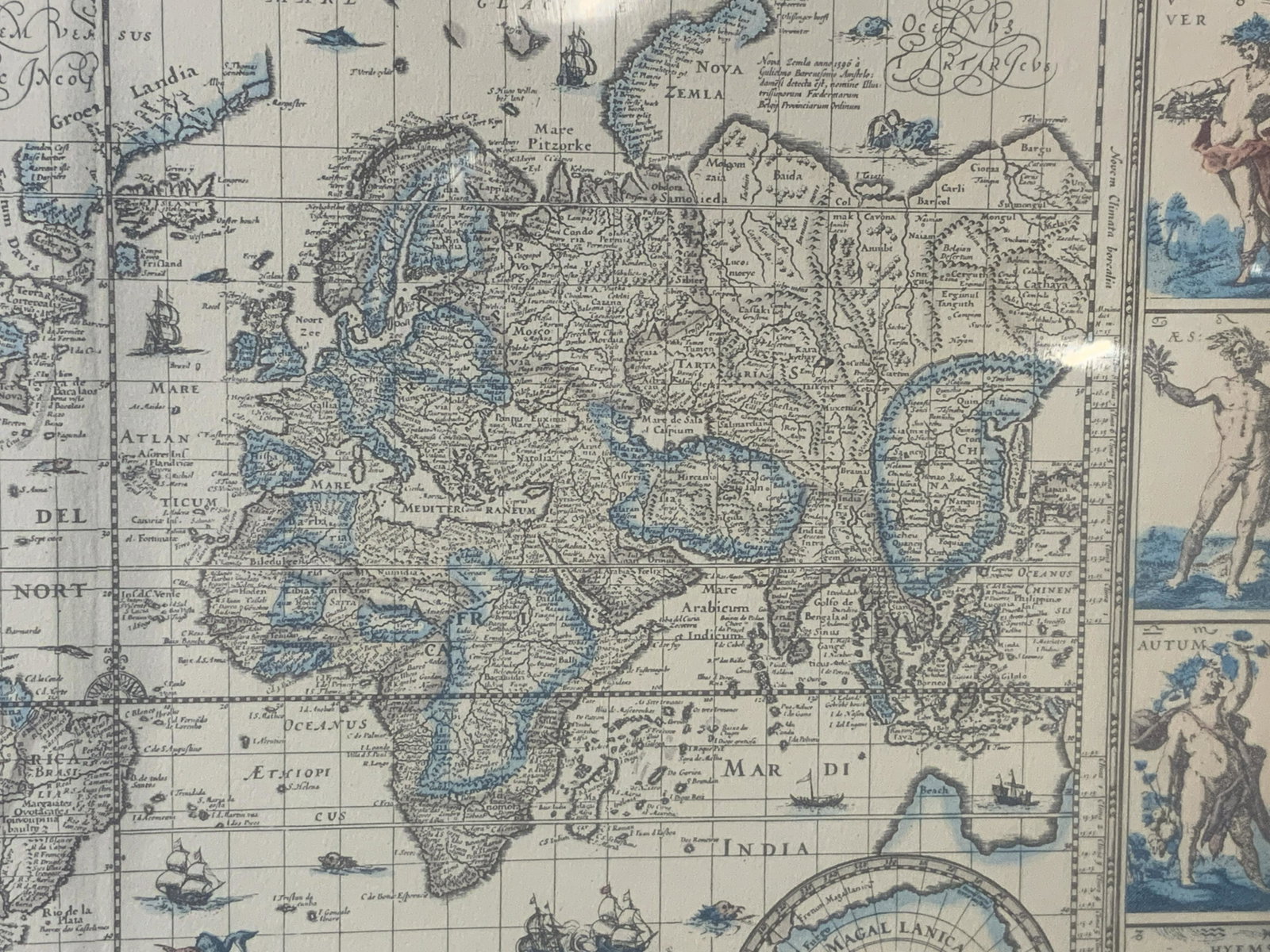 Framed Lithograph of Latin Map of the World: Framed Lithograph of Latin map of the world, Latin text throughout, map surrounded by pictorials of various scenes, tan matting, tan wooden frame, frame measures 17.5 inches tall by 21.5 inches wide, 