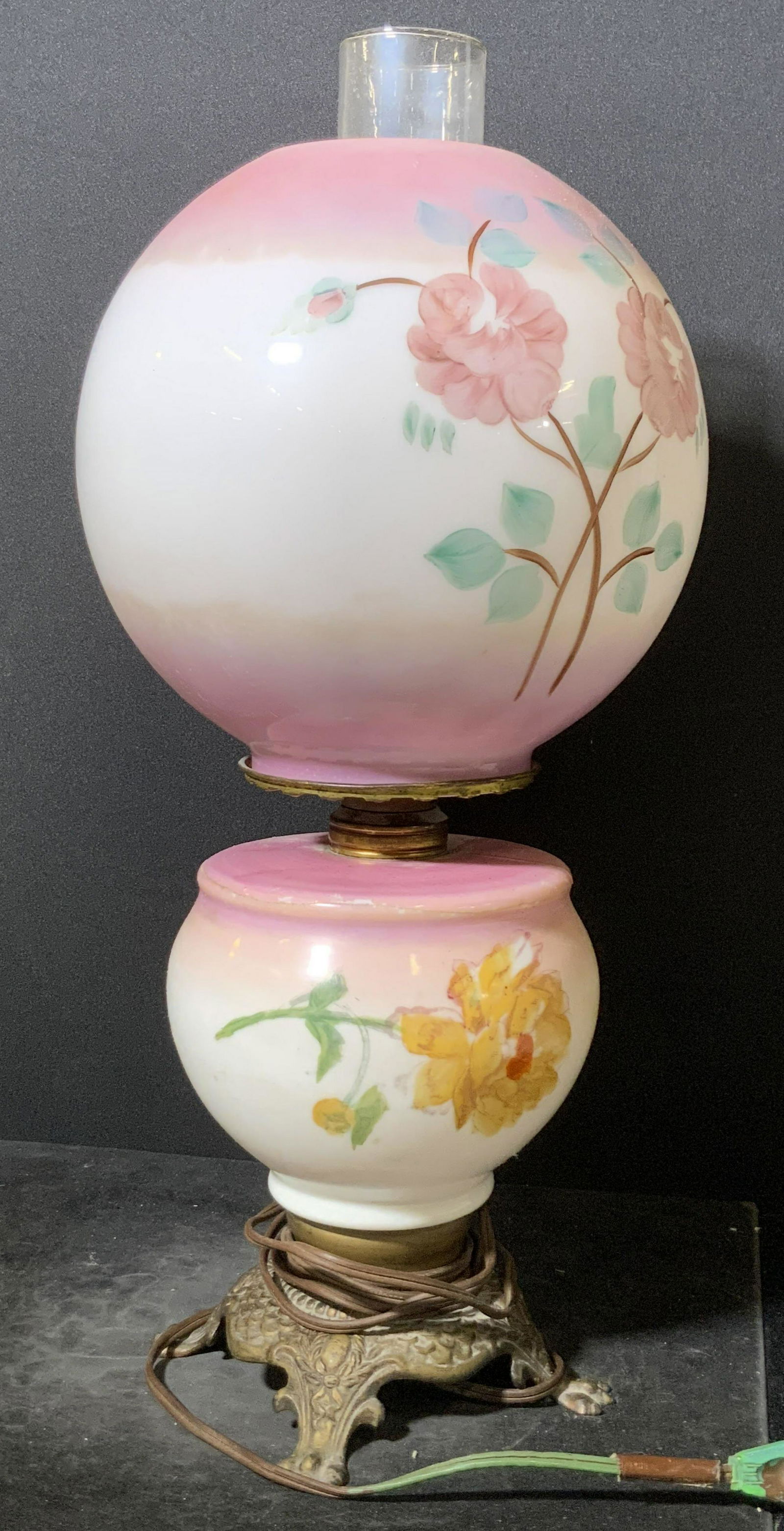 Vintage Gone With The Wind Style Art Glass Lamp: This vintage Gone With The Wind style lamp is crafted from thick walled glass and metal. Possibly bronze. Piece features hand painted floral designs throughout. The base has clawed feet and etched met