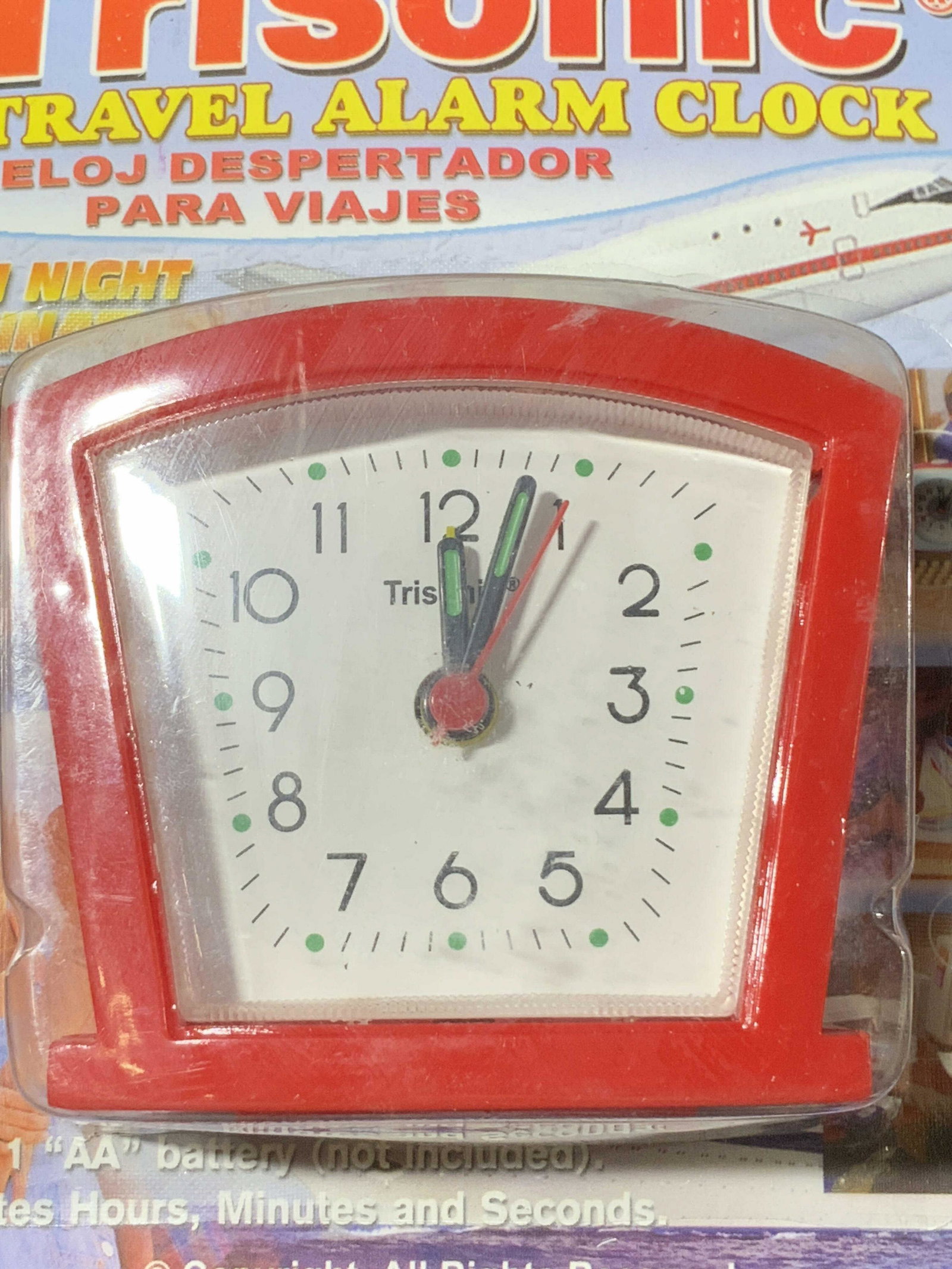 2 TRISONIC & TELSTAR Travel Alarm Clocks, Org Pack: Two red hued travel alarm clocks crafted from composite materials. Both are battery operated and have white clock faces. The TRISONIC clock is still within its original packaging. The TELSTAR clock fo