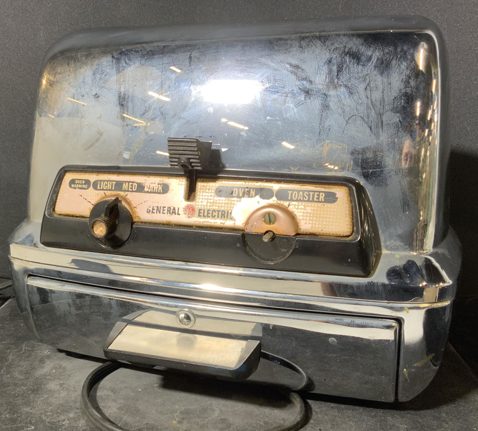 Vintage GENERAL ELECTRIC Toaster: A vintage polished silver tone metal toaster. Obverse reads GENERAL ELECTRIC. Underside also reads GENERAL ELECTRIC. Piece has surface wear and wear consistent with use & age. One knob missing from ob