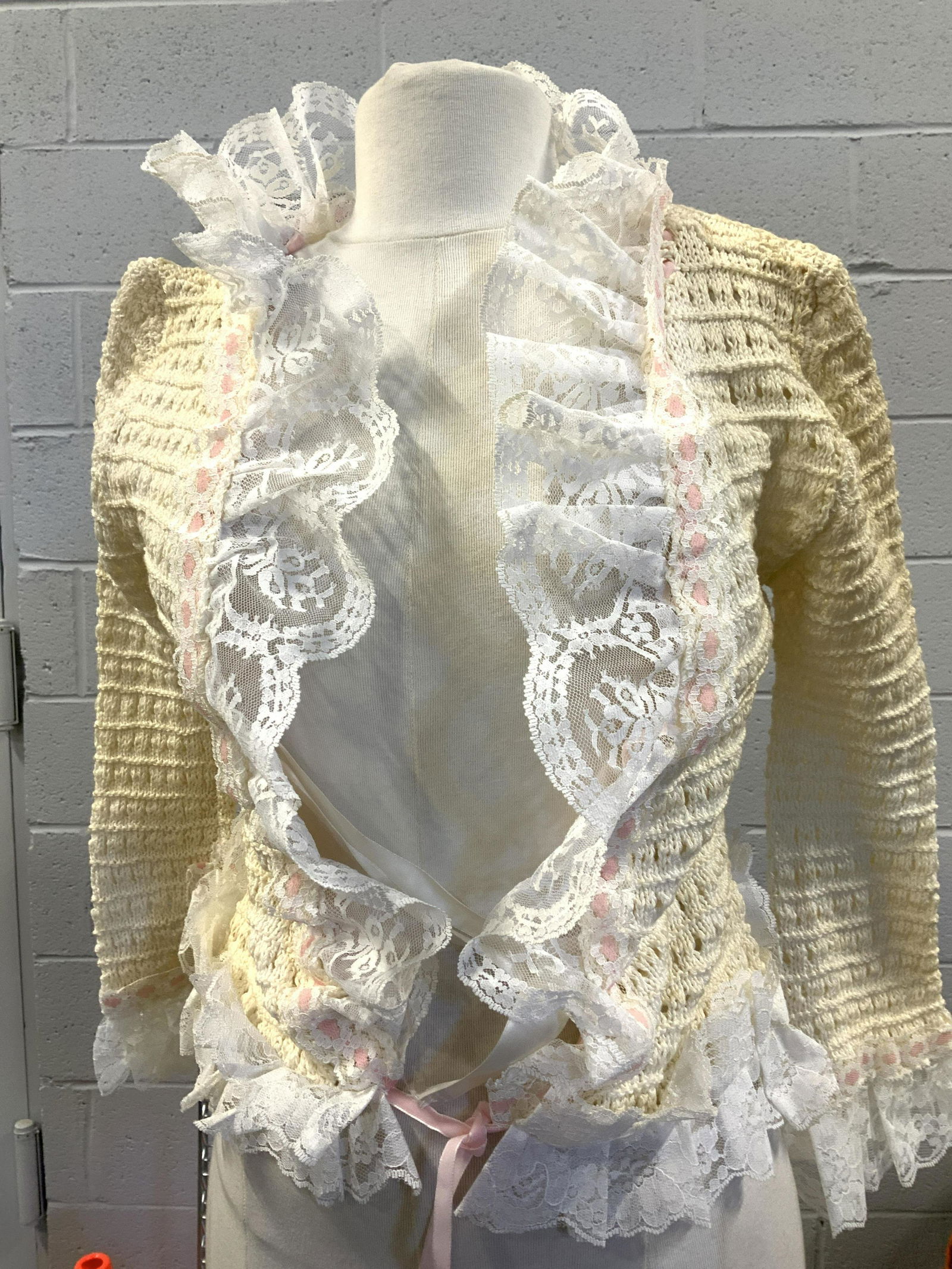 Handmade Knit Cotton and Lace Open Sweater: Size Xtra small to small handmade knitted/ crochet sweater with Ruffle lace on cuffs and sweater rim, collar and down center opening adorned with pink ribbon that cinches along hem to tie. Additional