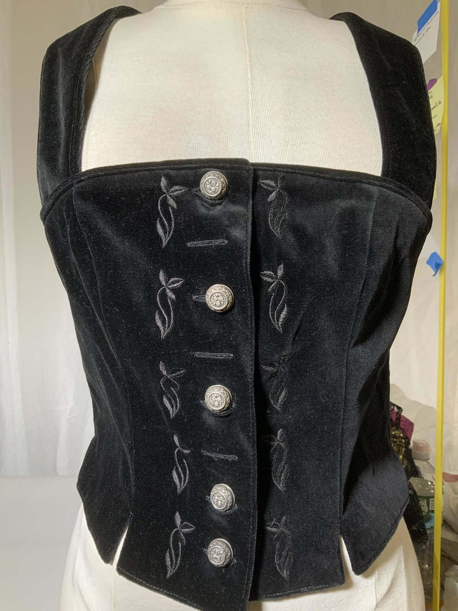 Trachren Forstenlenchner Blk Velvet Vest, more: Black velvet/ velour ladies vest with stylized pewter buttons, style similar to barmaids bodice with straps. App 29-30 in. Wide. 11 in long. Comes with layered ruffled arms sleeves with long black vel