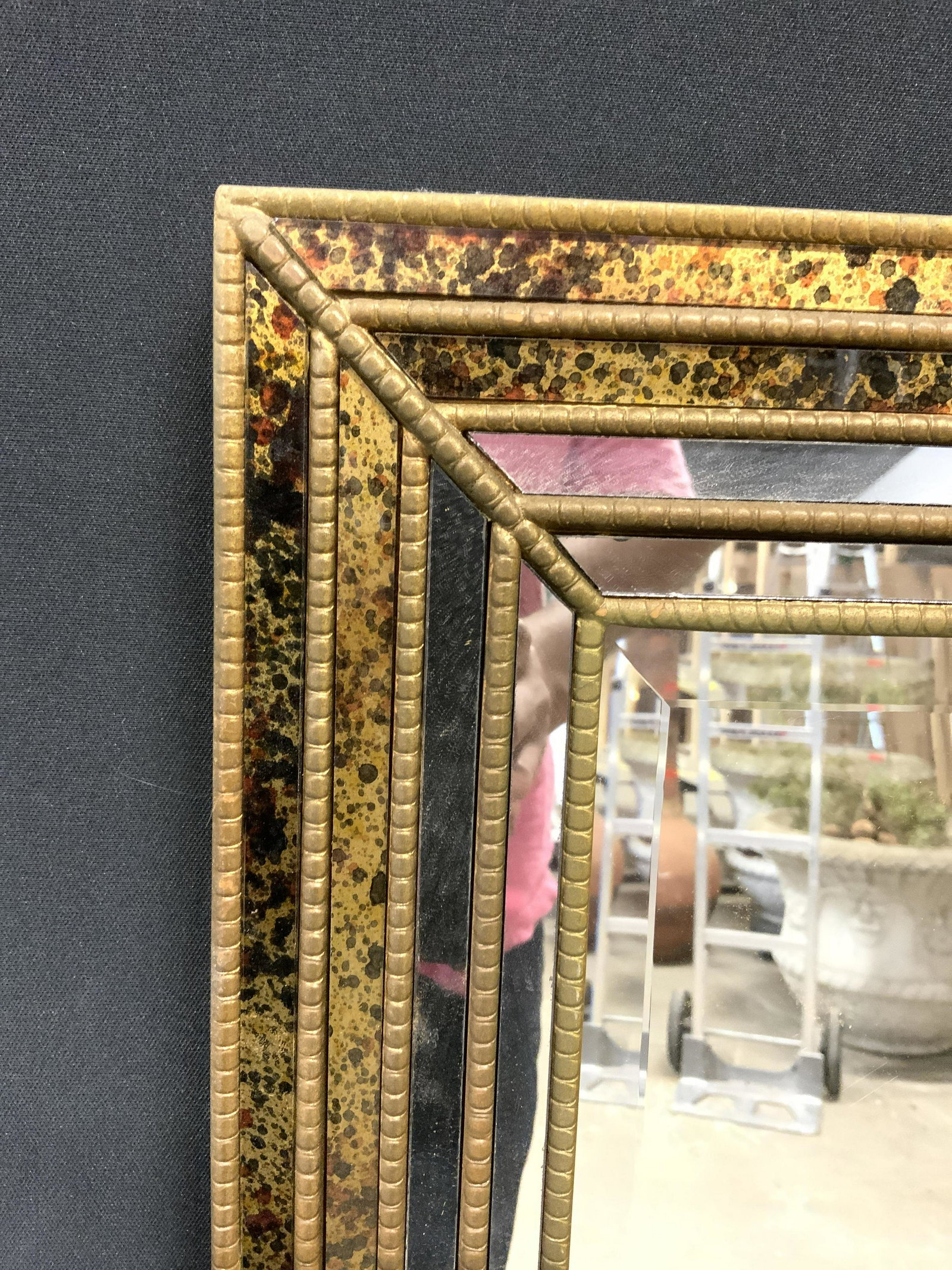 Beveled Multi Panel Wall Mirror: Center Mirrored surface is beveled. Piece has multiple panels on each side with gold toned detail in between. Piece measures approx. Measures approx 46.5 inches tall 31 inches wide. Mirror, wall mirro