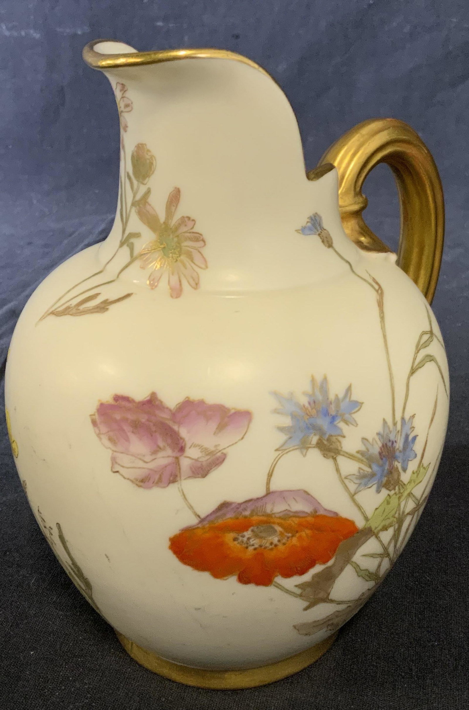 ROYAL WORCESTER ENGLAND Ceramic Pitcher: Ceramic pitcher, appears to be hand painted, decorated with floral prints. Gilt paint colors the handle, rim, and highlights the flowers. Underside reads as ROYAL WORCESTER ENGLAND, RdNo29115 1094. Me