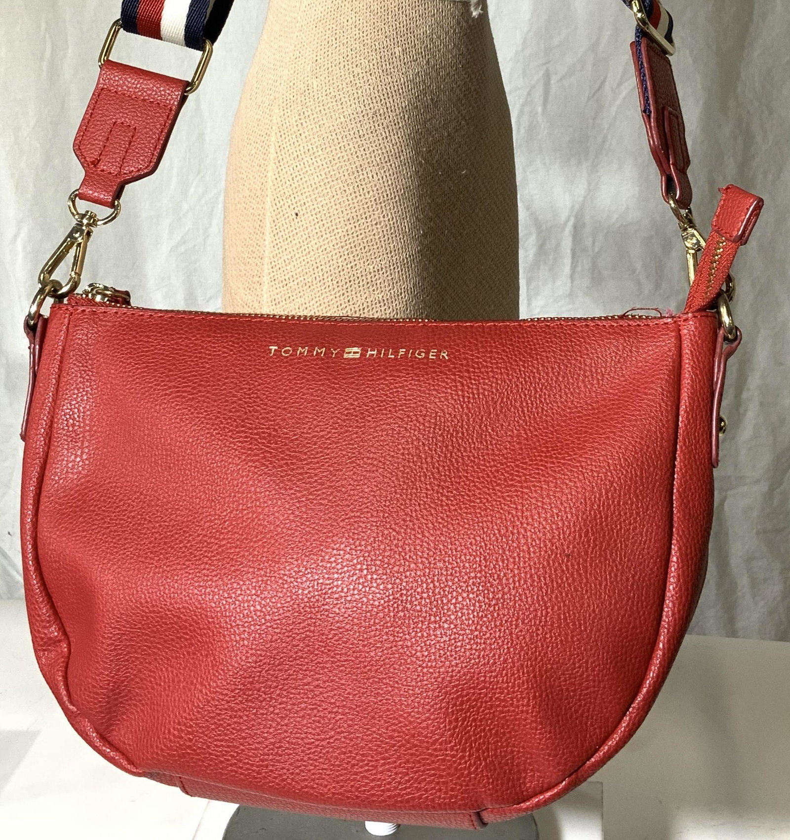TOMMY HILFIGER RED BOHO BAG: Signed designer bag with red, white and blue adjustable wide strap , 23.5 in. drop. Labeled synthetic leather , like new, clean inside and out, 10 x 7 in. Property of Palm Beach Estate ladies Fashion,