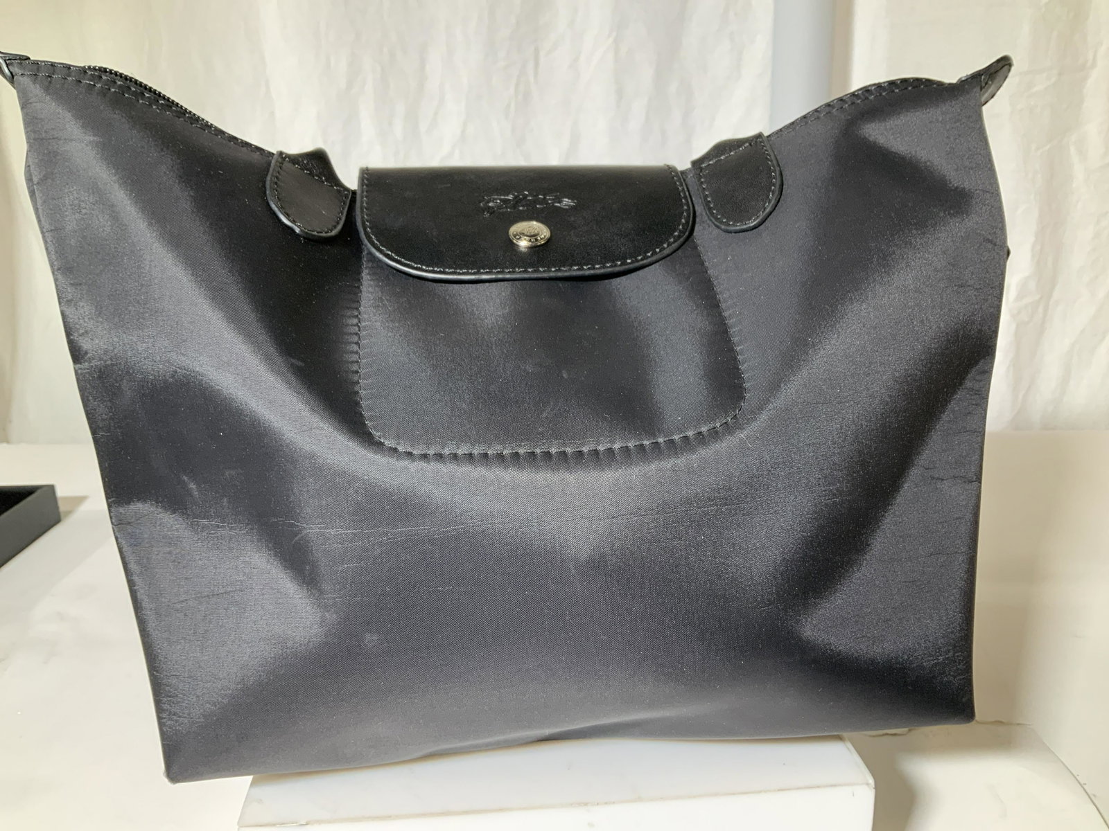 LONGCHAMP Nylon Lrg Shoulder Tote Bag, France: Black Nylon LONGCHAMP Tote, Made in France ( Marked and signed) Snap sloes, LONGCHAMP button, leather strap, drop 9 in. Clean inside and out. Very light surface lines to nylon. Pre owned, clean inside