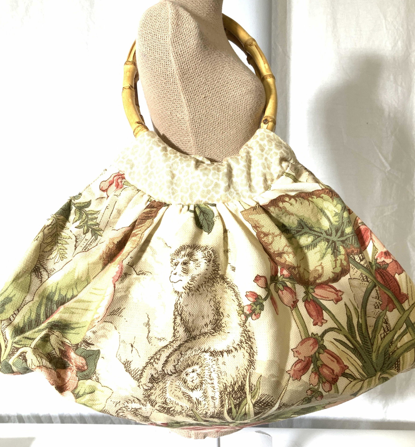 Bamboo Top Handle Monkey Satchel Bag: Handmade Fabric Handbag depicting animal print and monkeys in jungle scenery, polished bamboo handles 8 in drop. Made of thick woven cotton fabric. 14 x 8 in. Clean inside and out. Property of Palm Be