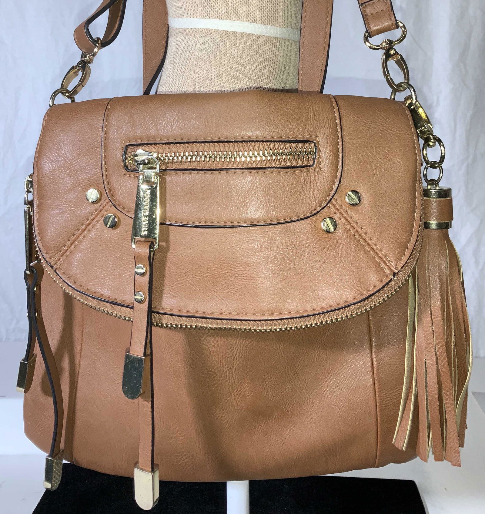 STEVE MADDEN Signed Leather Shoulder Bag: Lightly used Lt brown Steve Madden leather purse with fold flap , gold tone accessories, leather tassel. Works as a clutch , shoulder bag, or cross body, strap measures 24 in drop. Zippered Exterior p