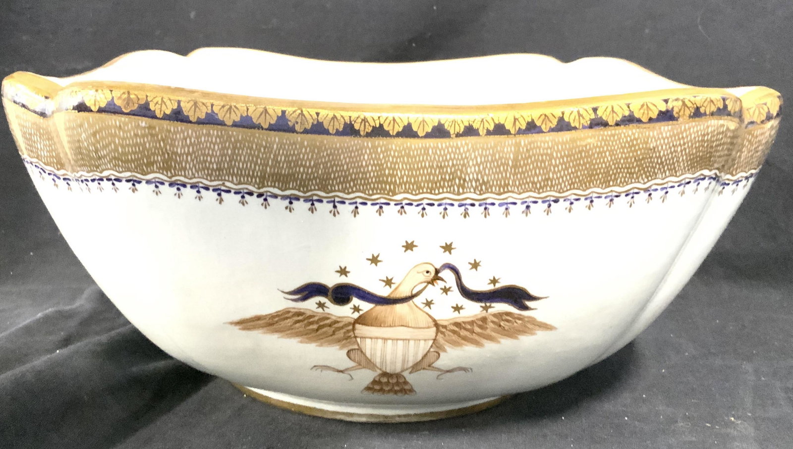 Vintage Hand Painted MOTTAHEDEH Porcelain Bowl: Underside of piece is marked MOTTAHEDEH. Bowl has hand painted elements. Detail features gold toned leaf pattern around rim, floral and leaf detail, and image of bird holding ribbon. Piece measures ap