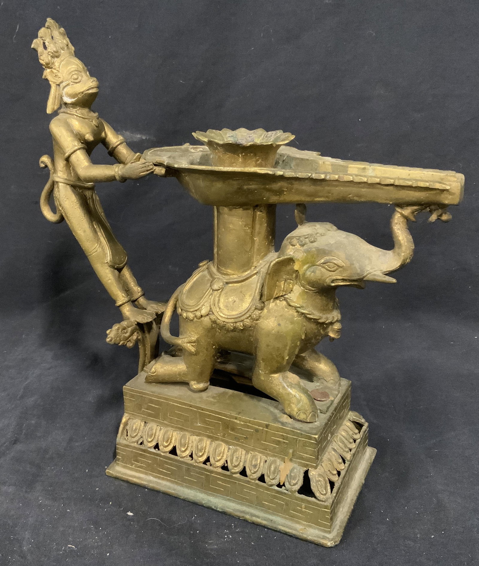 Vintage South Asian Candlestick Holder: Vintage brass candlestick holder, south Asian. Depicts a monkey like figure and an elephant supporting the structure that holds the candle. Measures approx 10.25 inches H, and 10.5 inches W. Wear is c