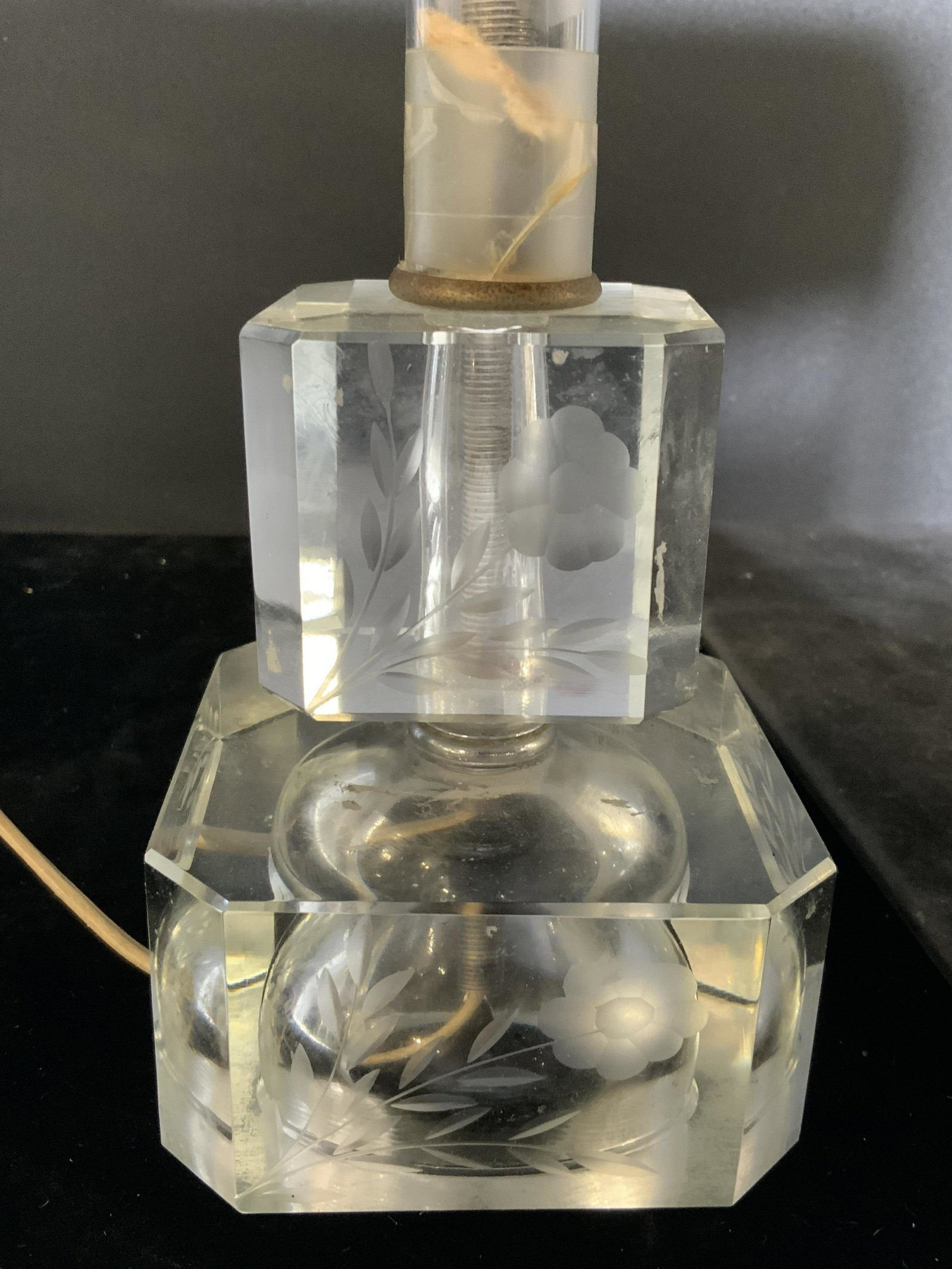 Frosted Floral Detailed Glass Table Lamp: Lamp is glass. Piece has frosted floral & leaf detail. Center of piece has cylindrical shape. Piece has 2 tier base. Lamp measures approx 16 inches tall 3.5 inches wide and deep. Lamp, side table lamp