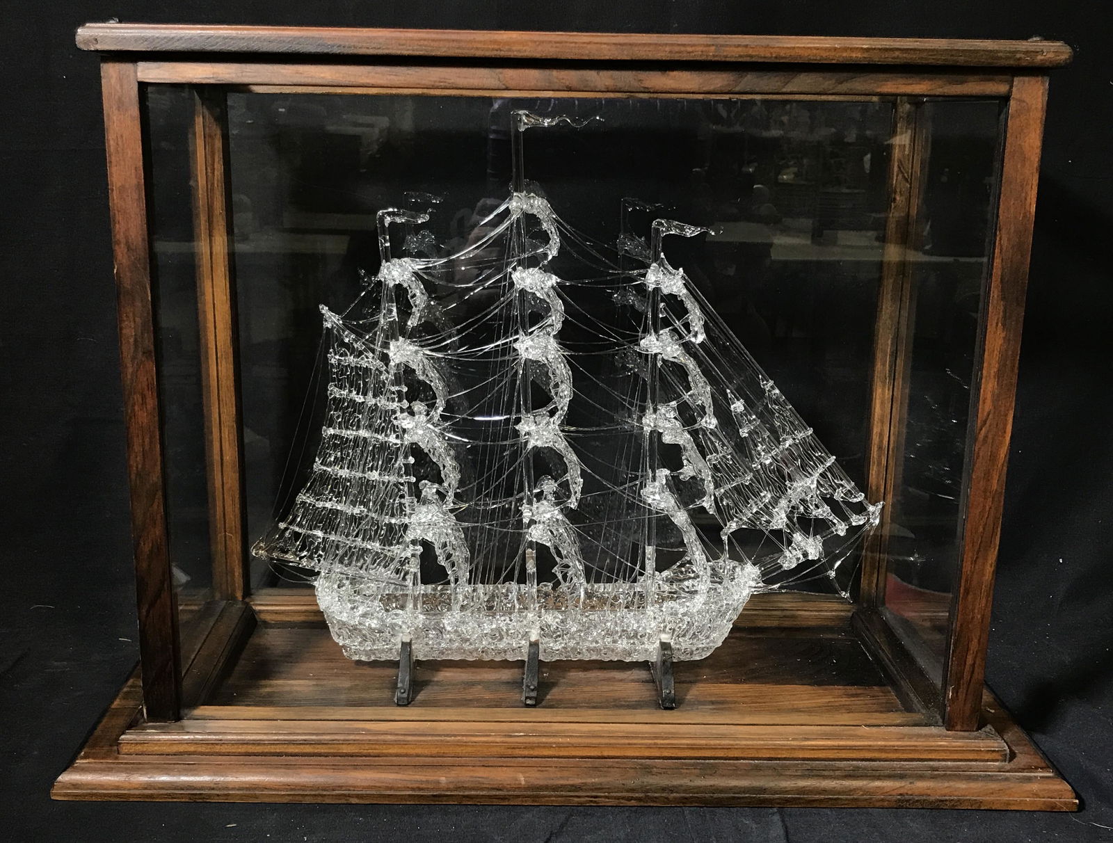 Hand Crafted Crystal Ship: Hand Made Crystal Ship, no apparent signatures or stamps, ship made of a delicate clear crystal with three masts, ships is held up by three wooden prongs, ship is contained in a glass and wooden case,