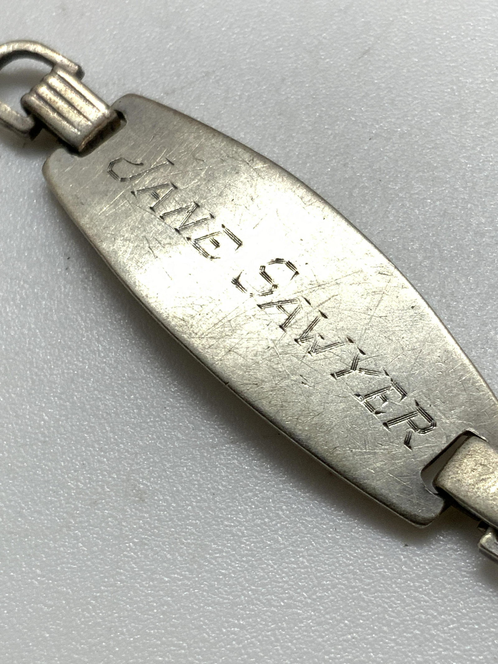 JANE SAWYER Vntg Sterling Silver Hallmark Bracelet: A vintage sterling silver hallmarked name plate bracelet that reads JADE SAWYER on the topside. Letters have been etched in. Underside features hallmarks & reads STERLING. Secures with c-spring clasp.