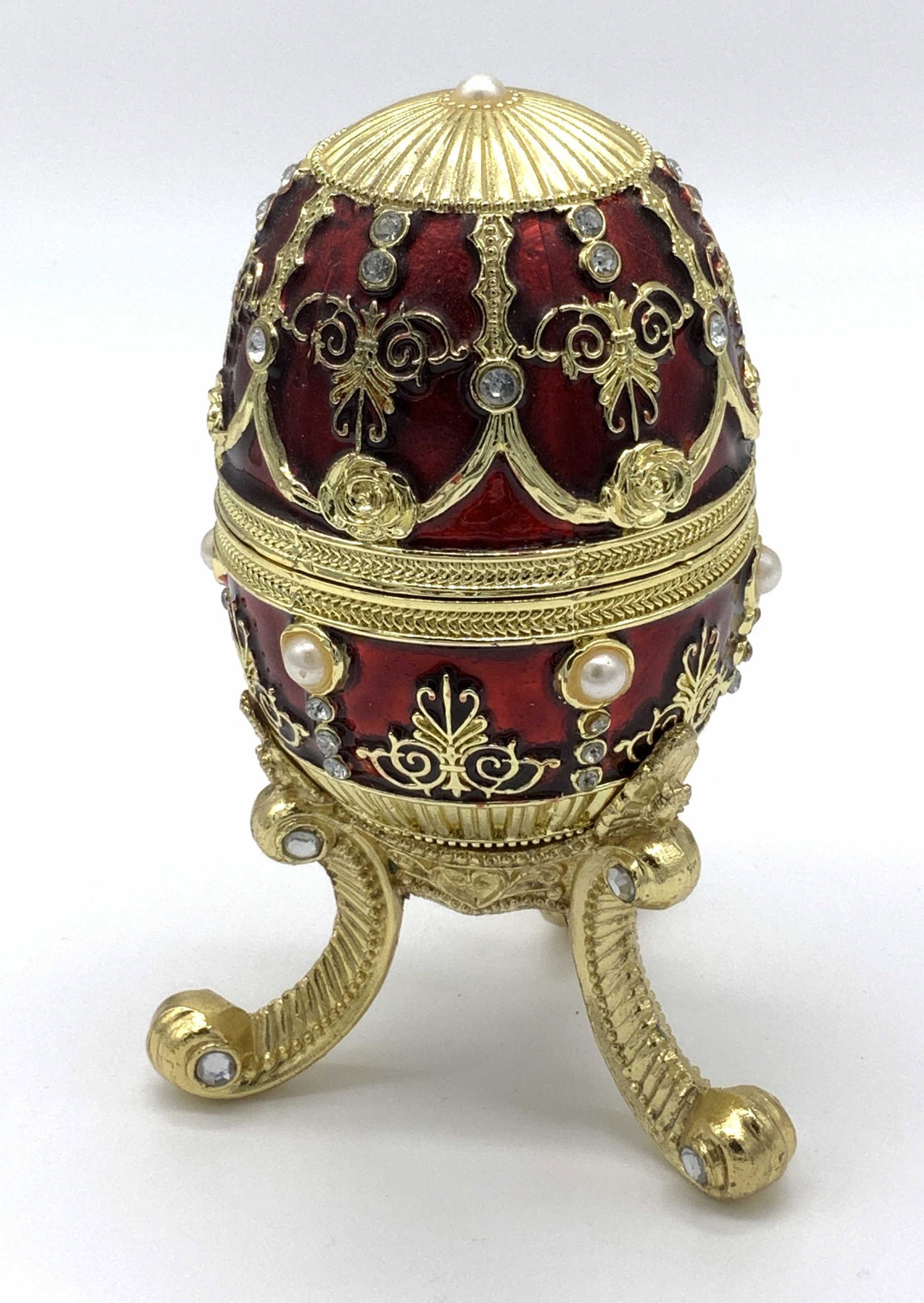 Faberge Egg Trinket Music Box: Faberge egg trinket music box, exterior decorated in red pearl and gold, no apparent inscriptions or markings , key to wind up music box located inside, interior lined with yellow felted fabric, egg m
