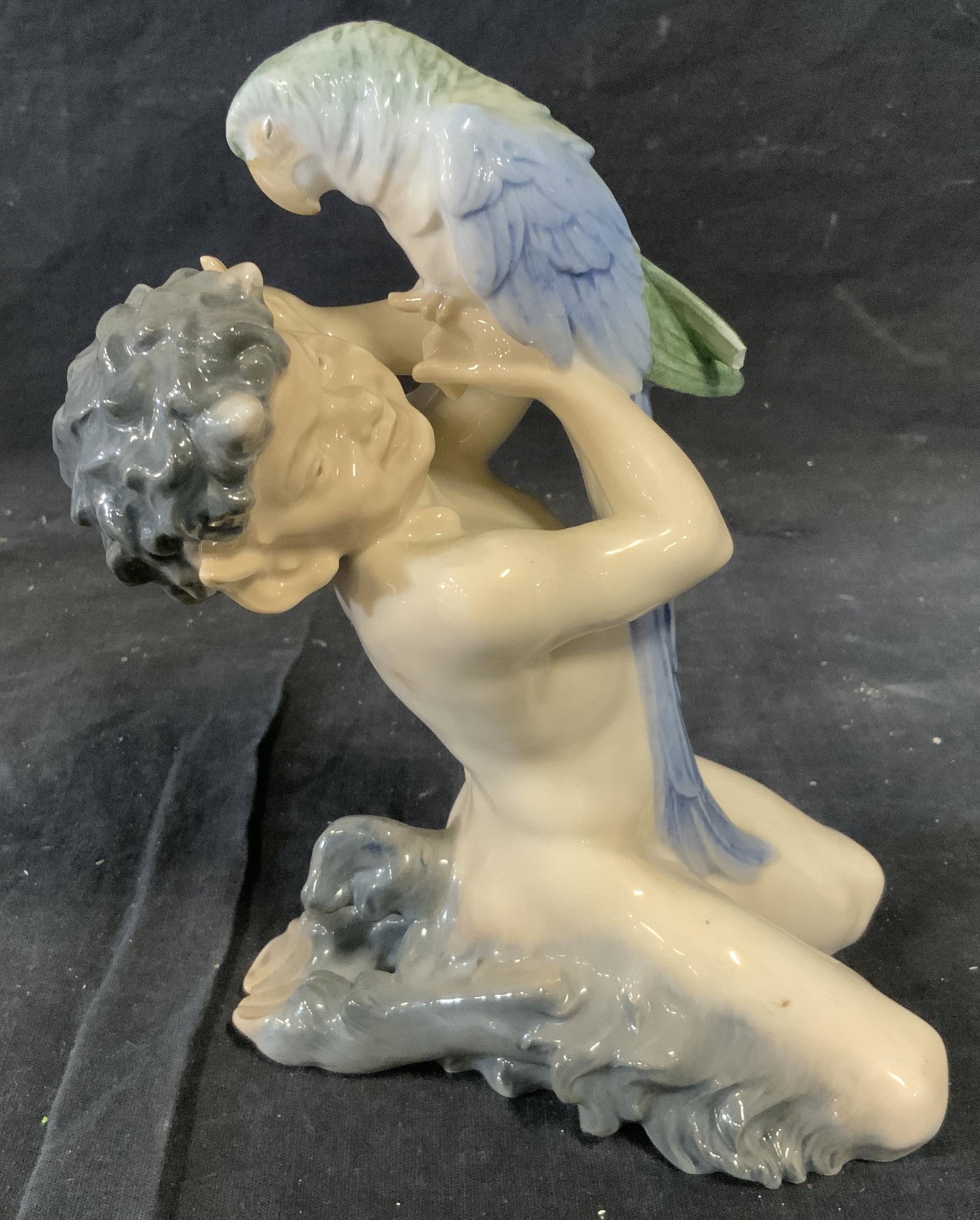 Danish Porcelain Figural Statue: Danish Porcelain Figural Statue, label to underside reads ‘Royal Copenhagen Denmark’, subject a satyr holding a blue and green bird, piece measures 7.5 inches at tallest point, some wear from age,