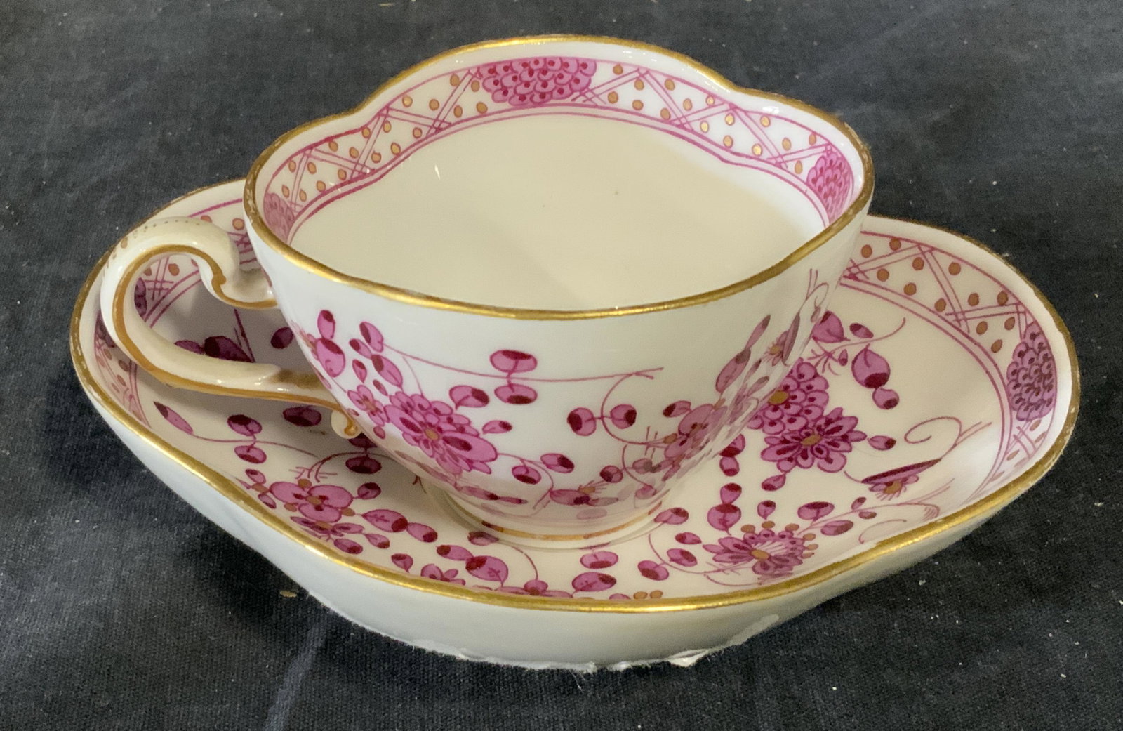Meissen Porcelain Teacup & Saucer: Meissen porcelain teacup and saucer, underside of each has the signature Meissen symbol, cup and saucer decorated with pink floral designs and gilding, saucer measures 5.5 inches by 4.5 inches, sticke