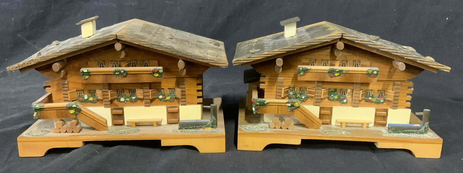 Lot 2 EDELWEISS Wooden Music Boxes: Lot of two wooden music boxes, each resembles a house. Floral detailing is hand painted. Each measures approx 4.5 inches H and 7.5 inches W. Labels on underside read as EDELWEISS. A hinge on one of th