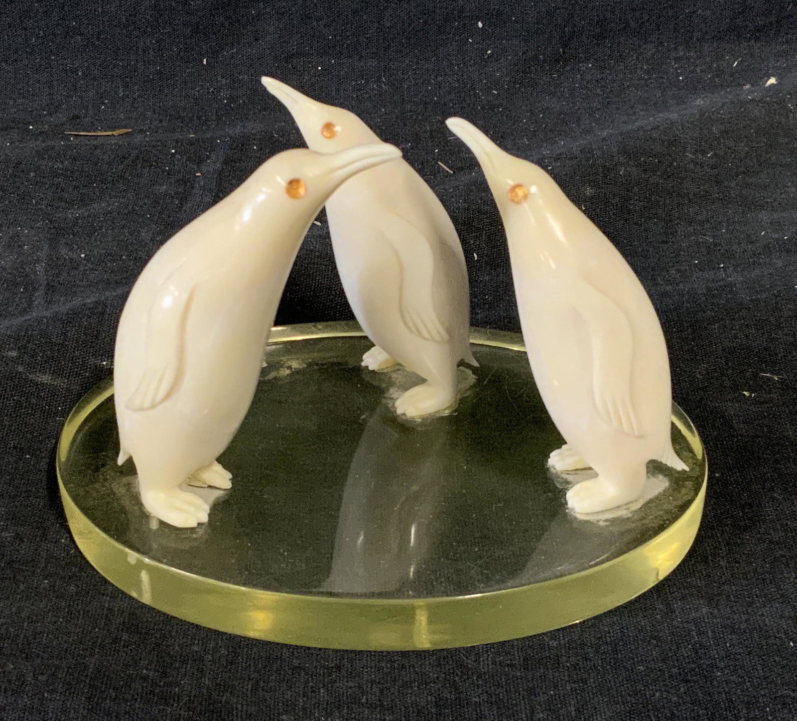 Resin Penguin Sculpture: Resin penguin sculpture, no apparent inscriptions or markings, subject three white resin penguins attached to a clear base, each penguin has a amber colored eye, piece measures approximately 3 inches 