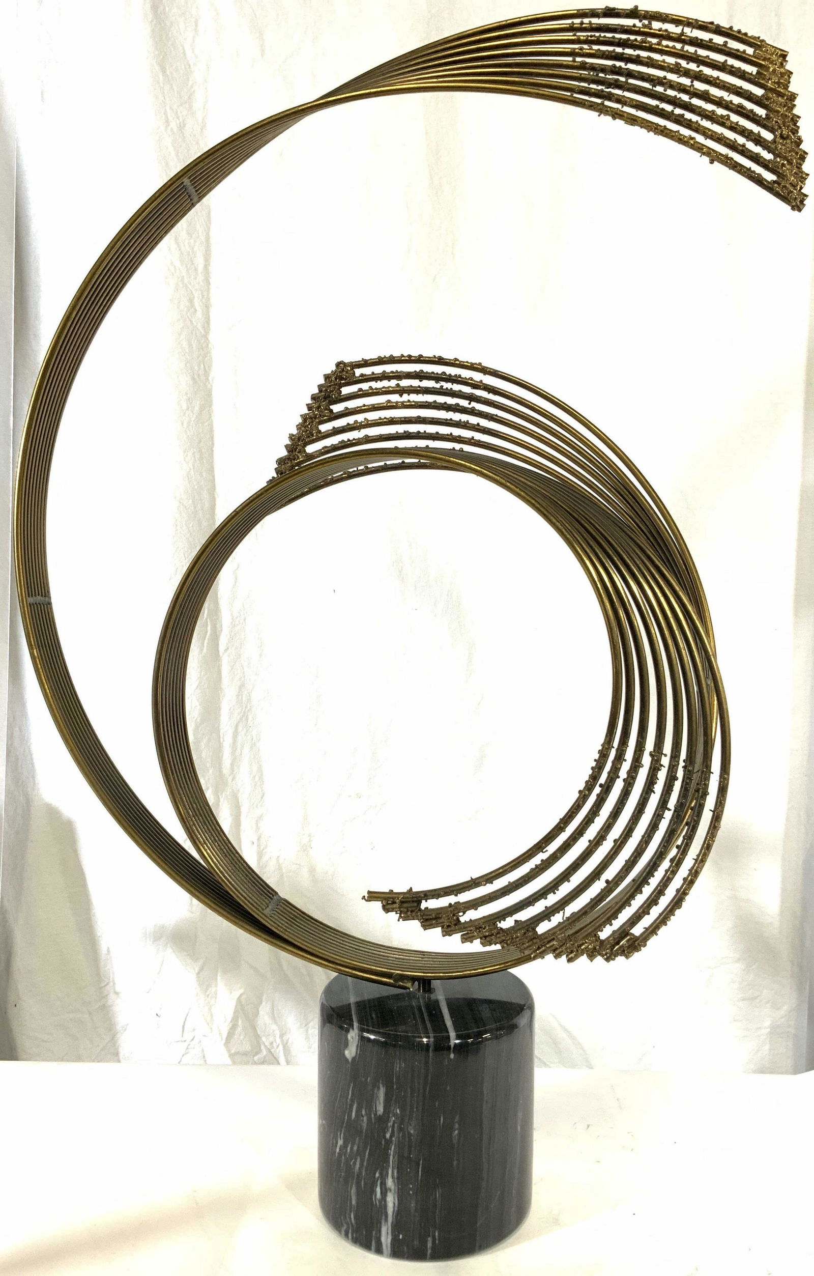 CURTIS JERE Signed Marble Base Sculpture: Piece is signed, appears to read Curtis Jere, mid century modern circa 1978. Sculpture has black toned cylindrical marble base. Piece is gold toned & possibly brass. Sculpture is a curved structure wh