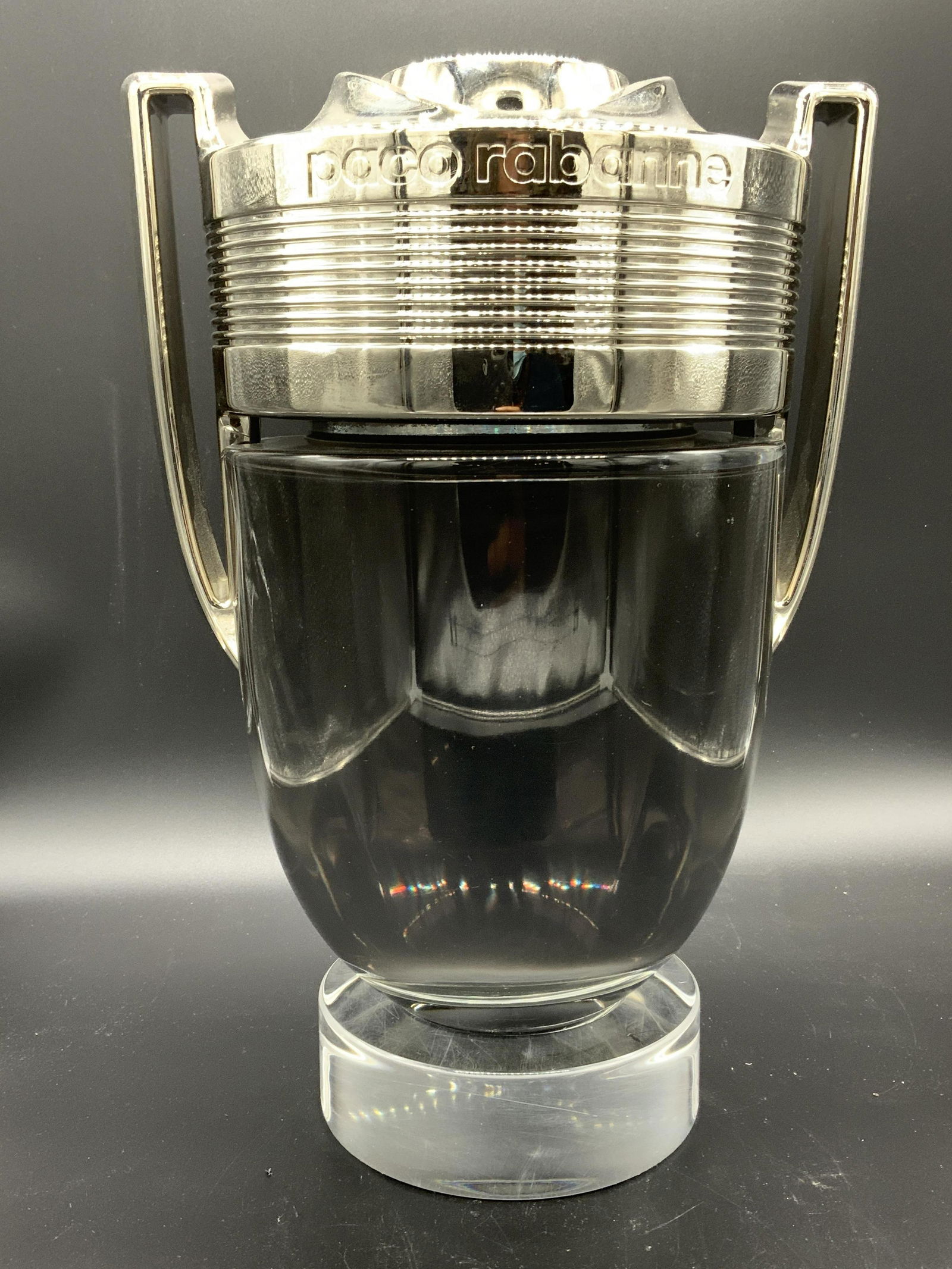 PACO RABANNE Perfume Bottle, Oversize Sales Sample: Oversized Bottle of the PACO RABANNE , Piece has Lid which appears to chrome with clear glass. These bottles draped the perfume counters of luxury department stores, such as NYC’s Flagship 5th Ave.