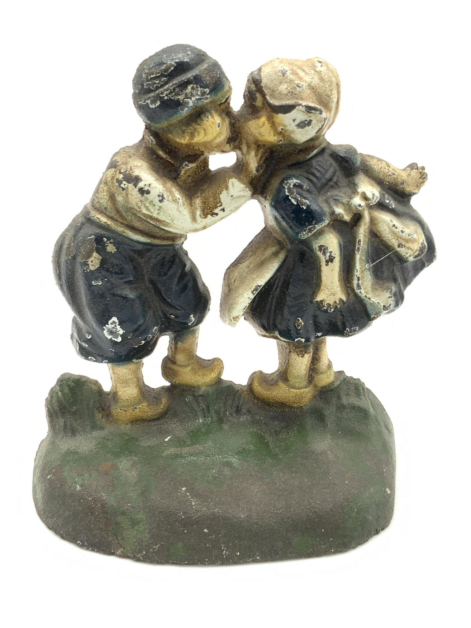 Vntg Hand Painted Iron Boy & Girl Figural Doorstop: Vintage, possibly antique, hand painted doorstop crafted from metal, possibly iron, and molded to resemble the form of a boy & girl sharing a kiss. Piece is primarily green, blue, and white hues. Appr
